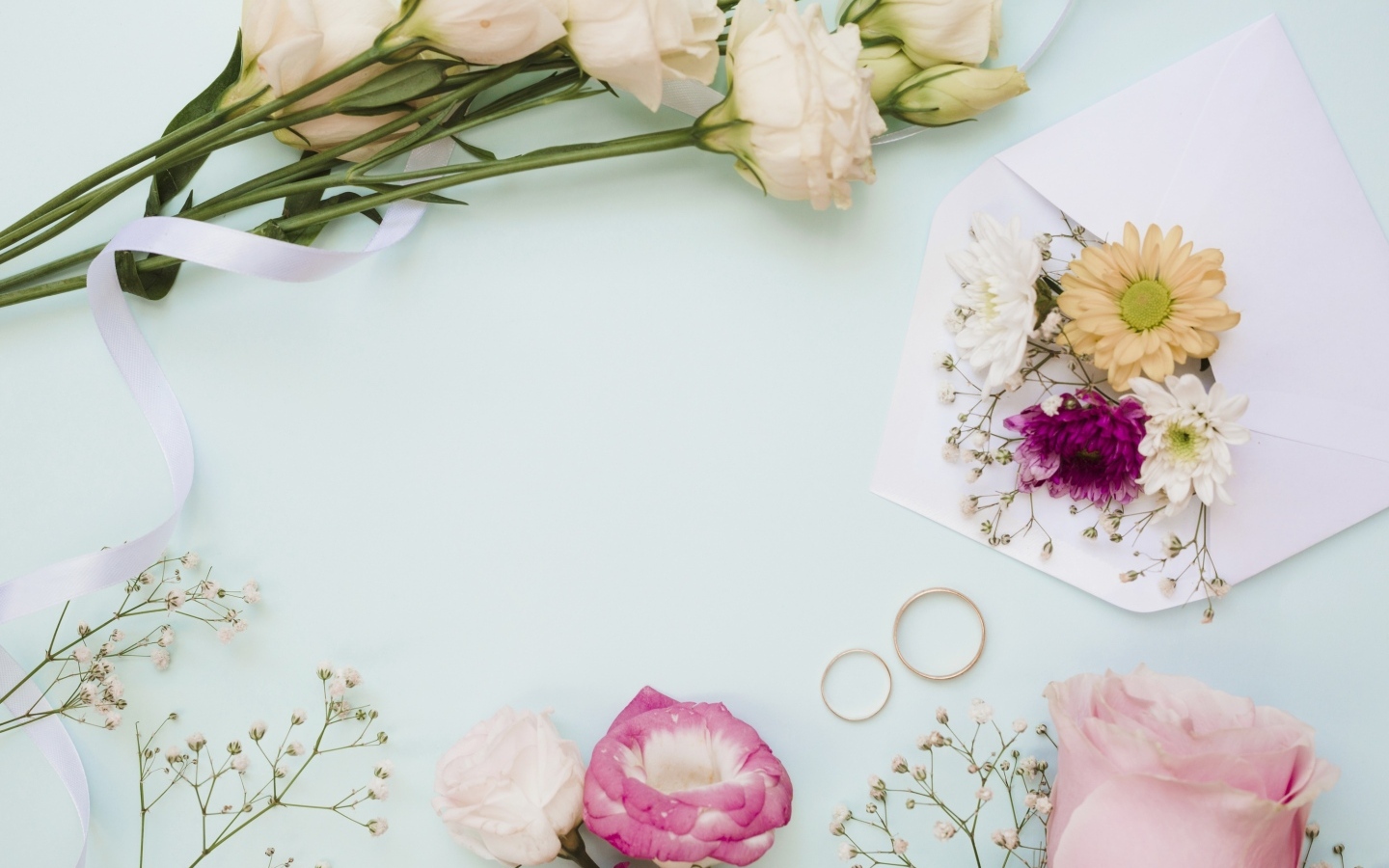 Цветы на голубом фоне с конвертом и обручальными кольцами