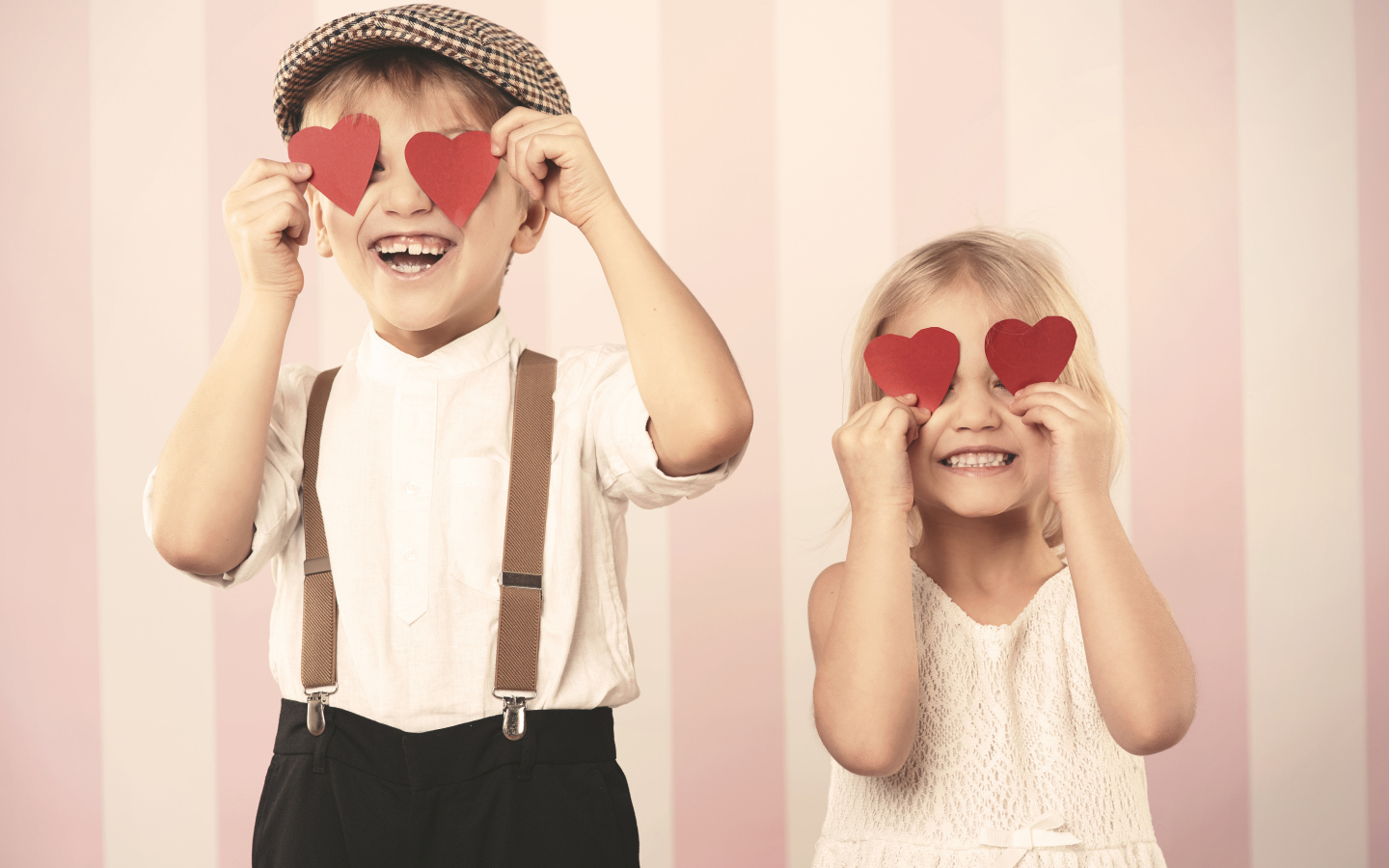 Мальчик и девочка с сердечками в руках