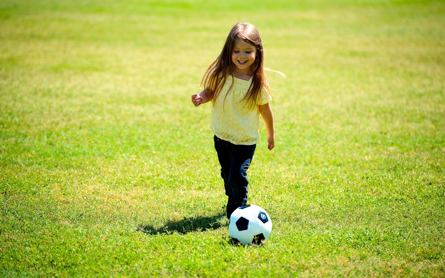 Девочка с футбольным мячом на поле
