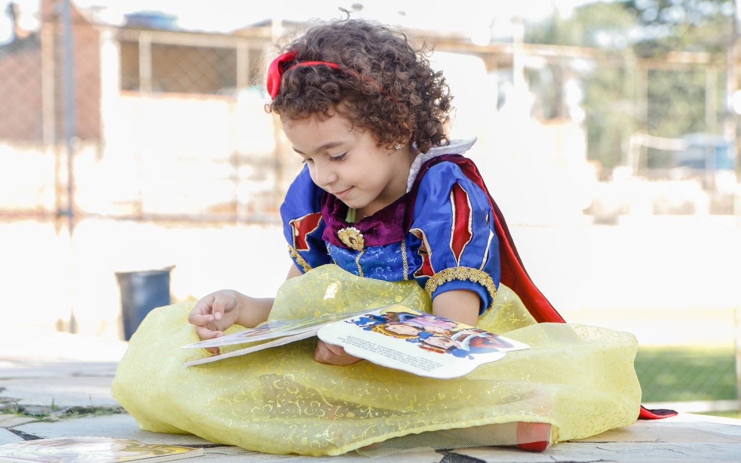 Маленькая девочка в костюме Белоснежки с книгой