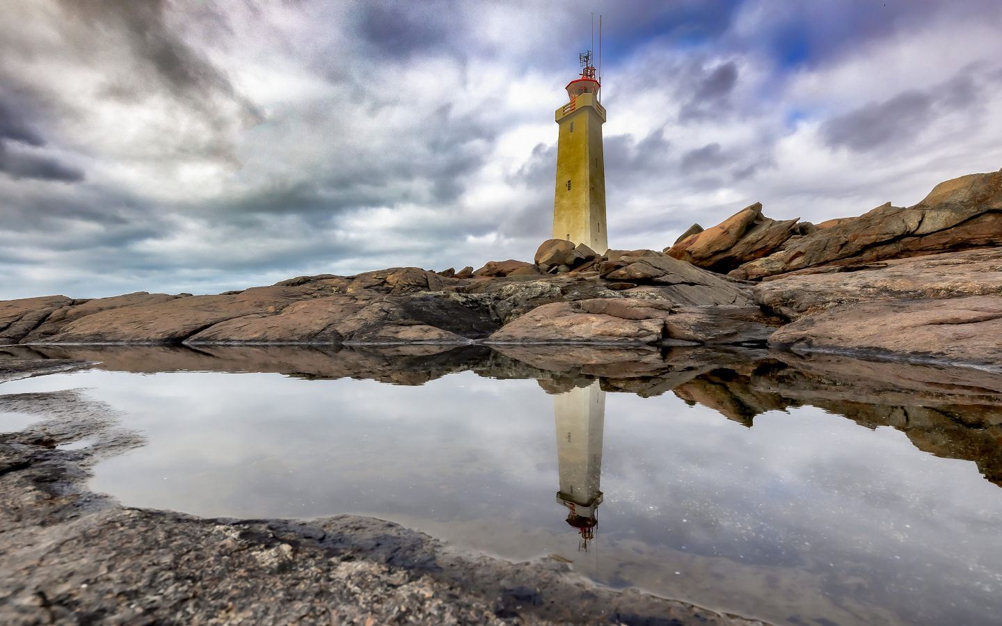 Маяк на больших камнях на берегу, Исландия