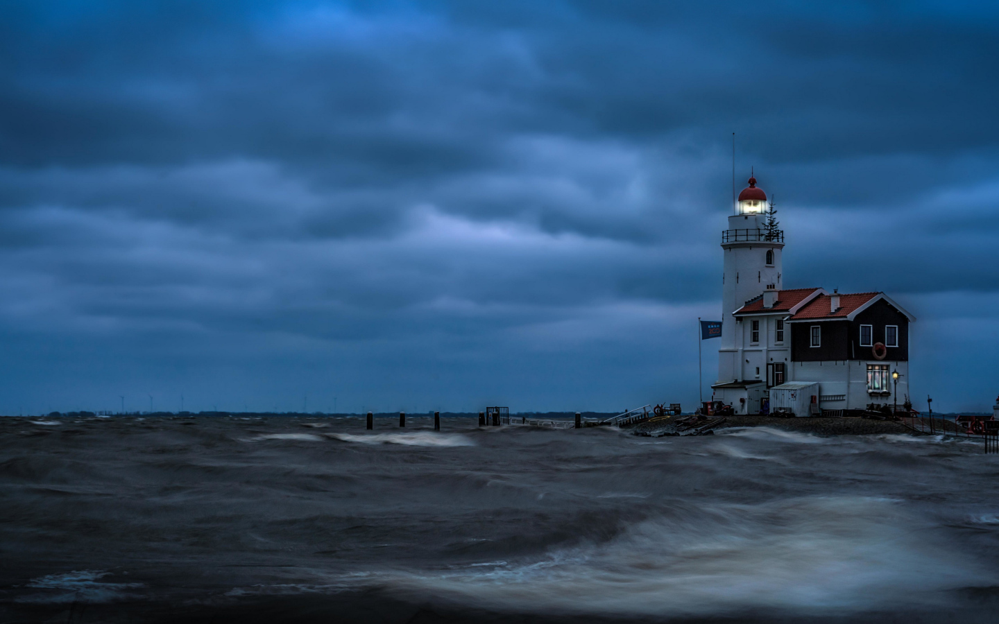 Маяк на морском побережье в сумерках, Голландия. Нидерланды