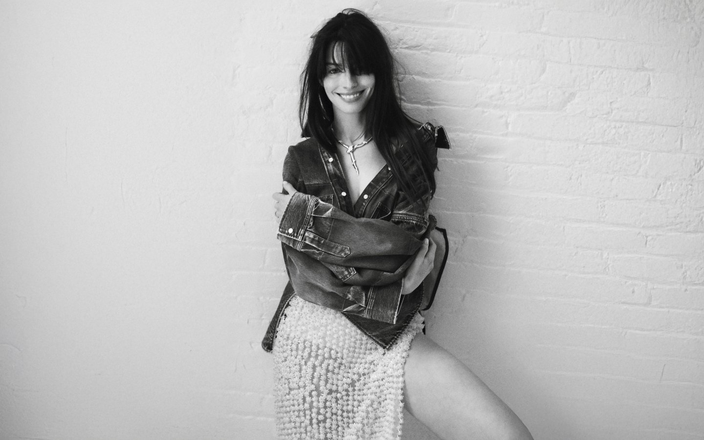 Актриса Энн Хэтэуэй стоит у стены черно-белое фото