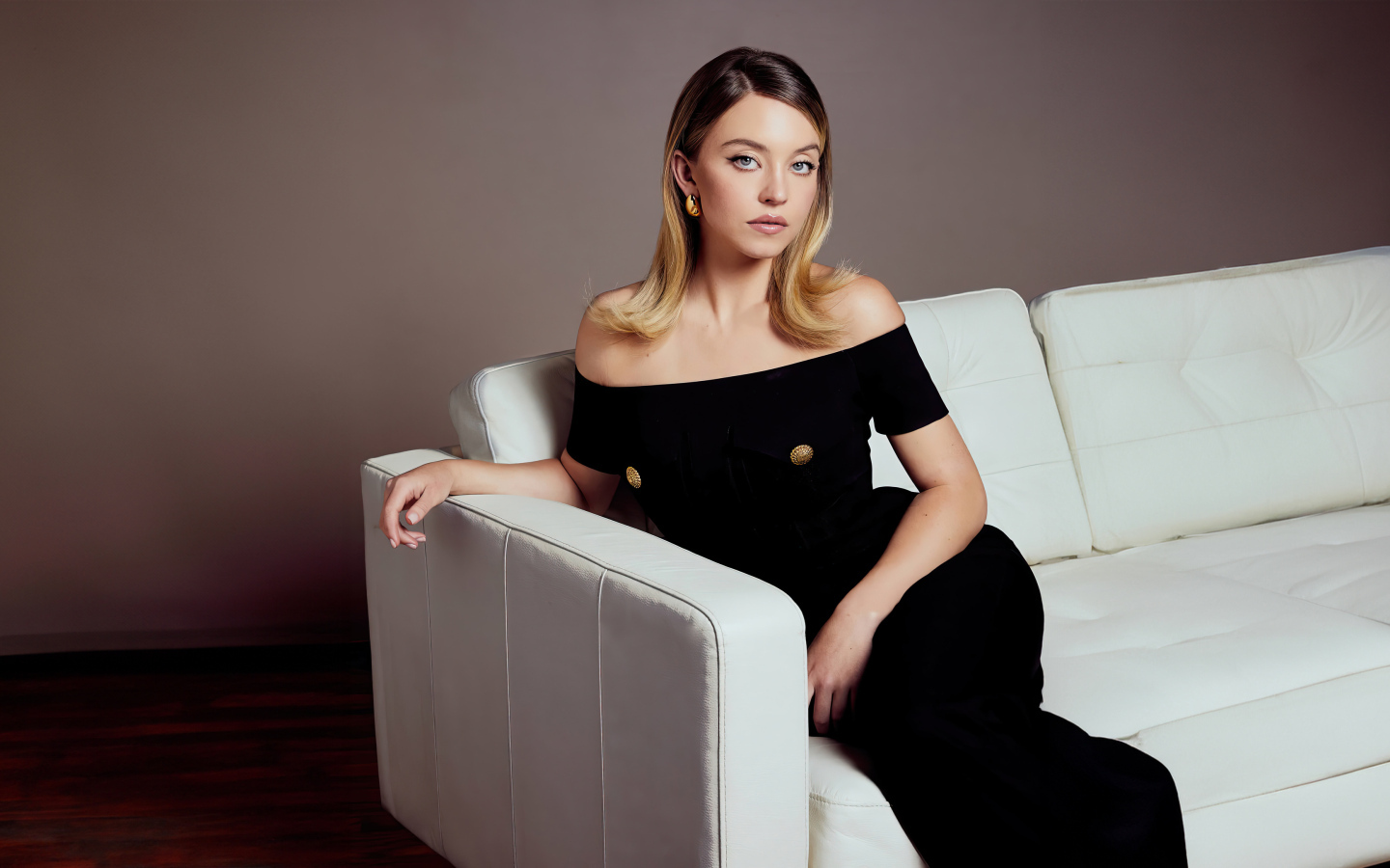 Милая девушка Сидни Суини в черном платье на диване