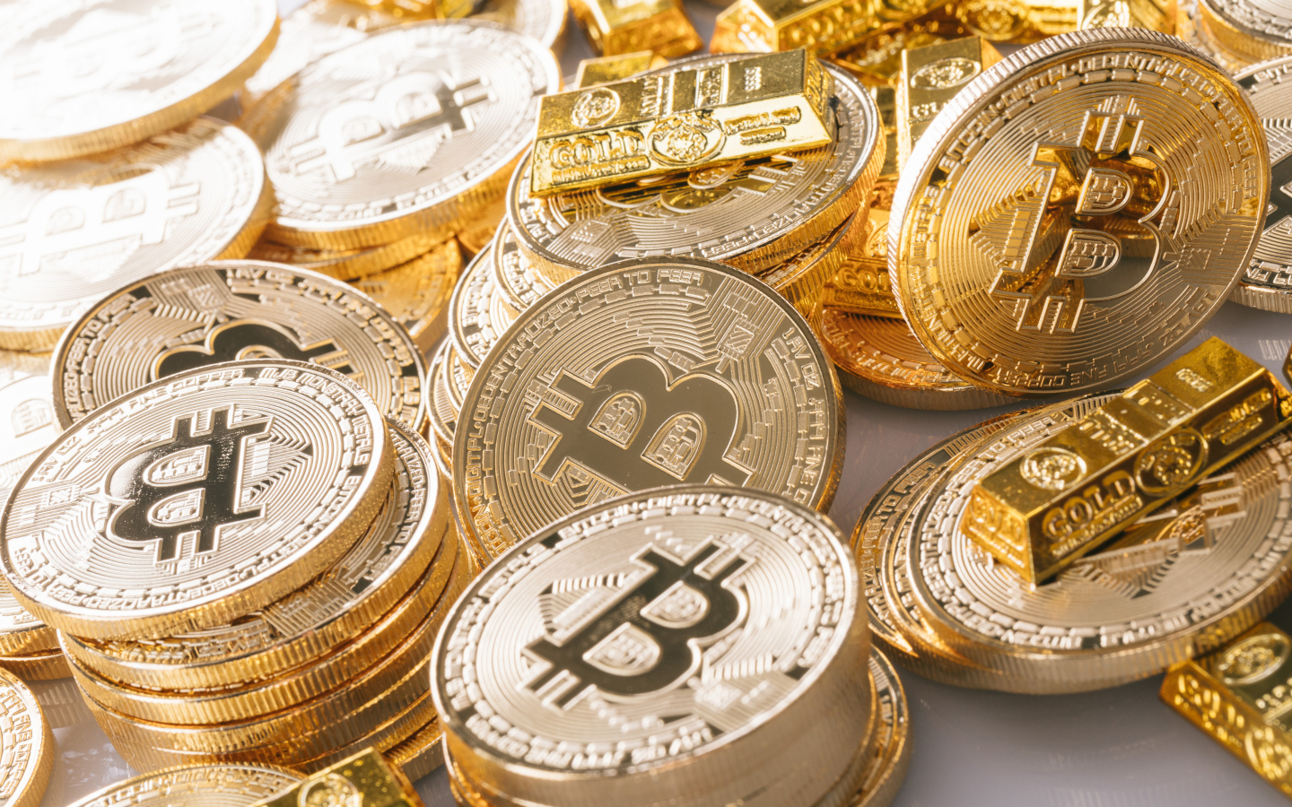 Золотые монеты биткоин со слитками