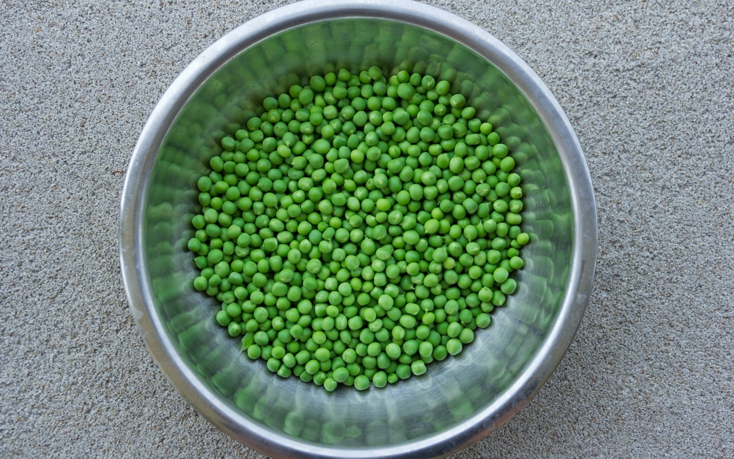 Зеленый горошек в жестяной миске на столе