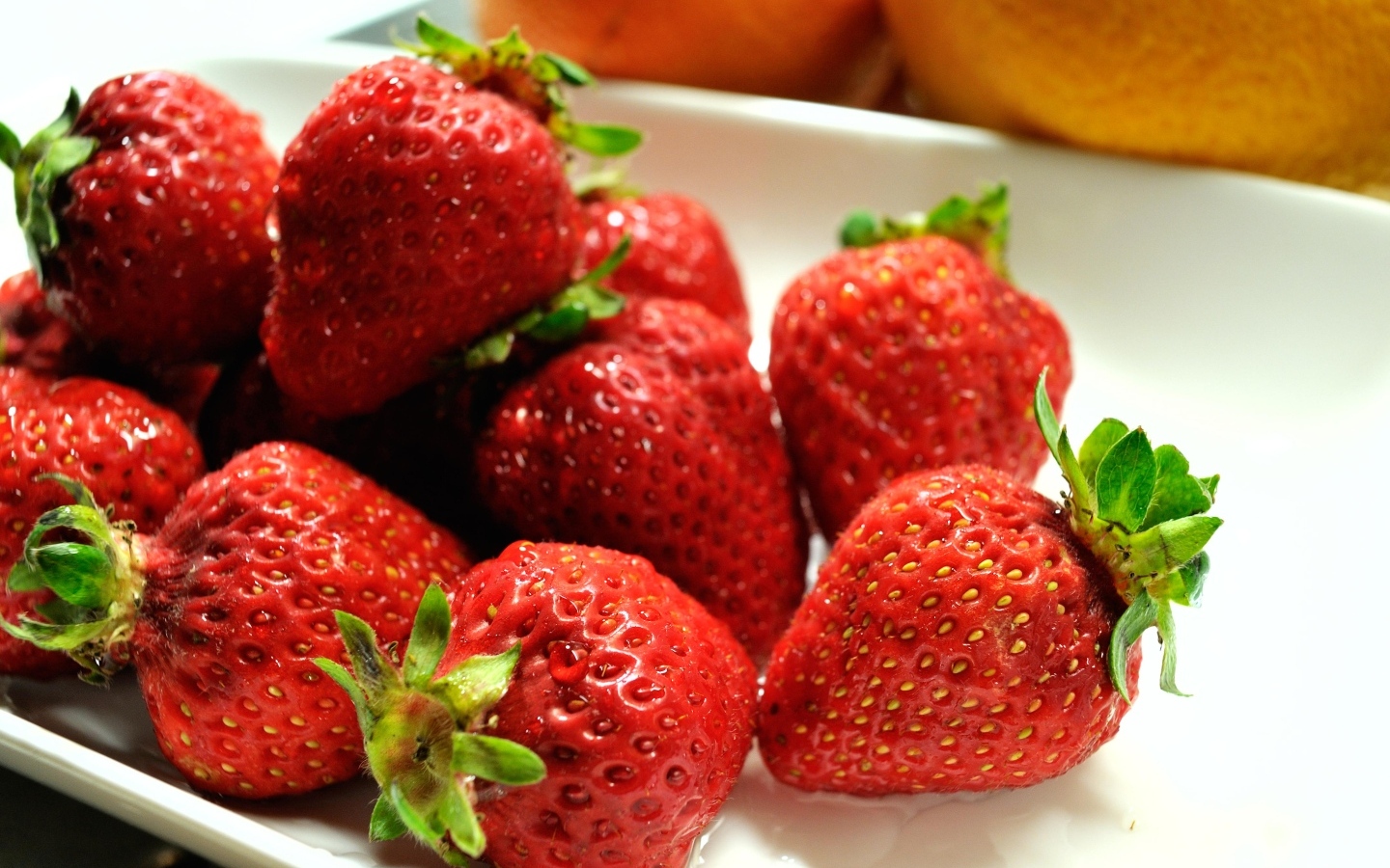 Ароматная красная клубника в белой тарелке