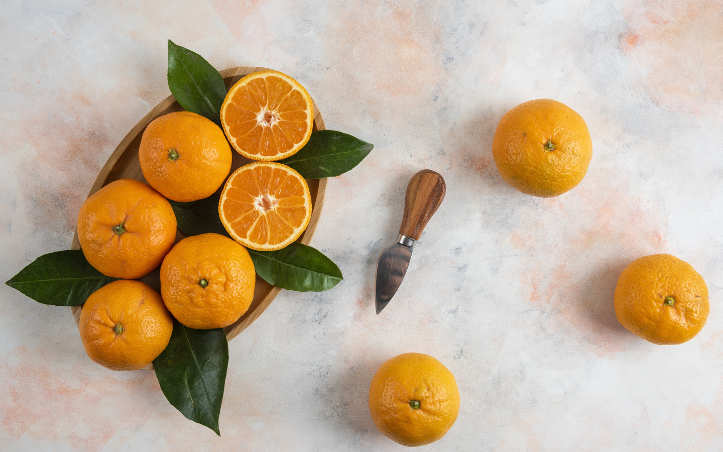Крупные апельсины на столе с ножом