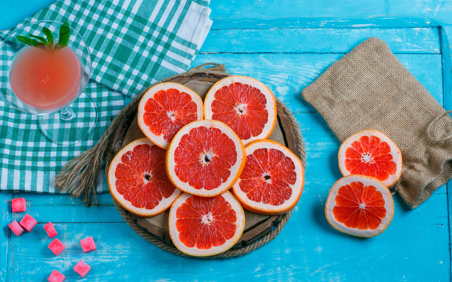 Нарезанный грейпфрут с соком на голубом столе