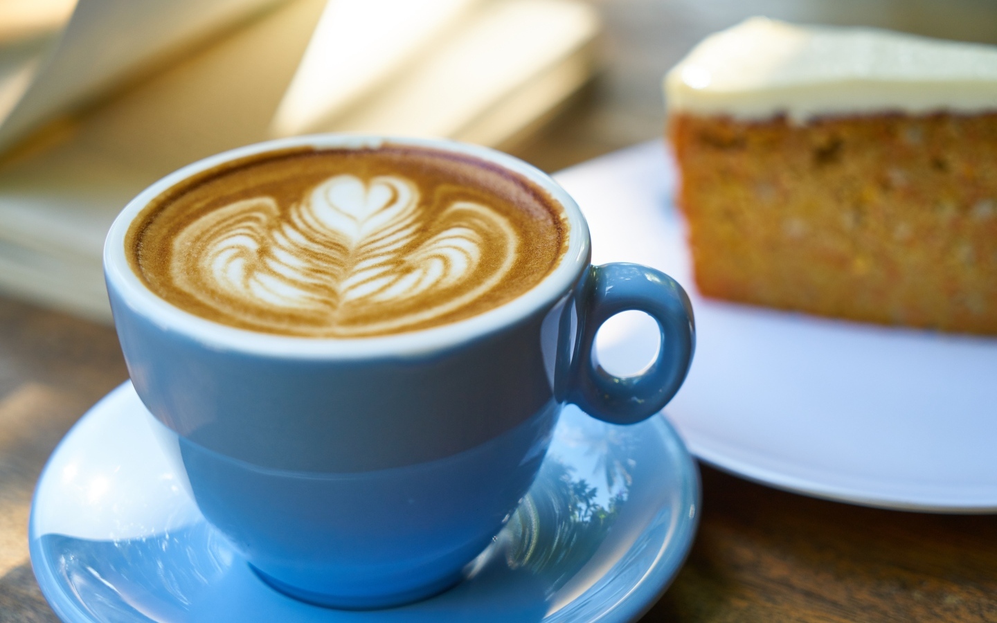 Чашка ароматного горячего кофе с рисунком на пене на столе на завтрак