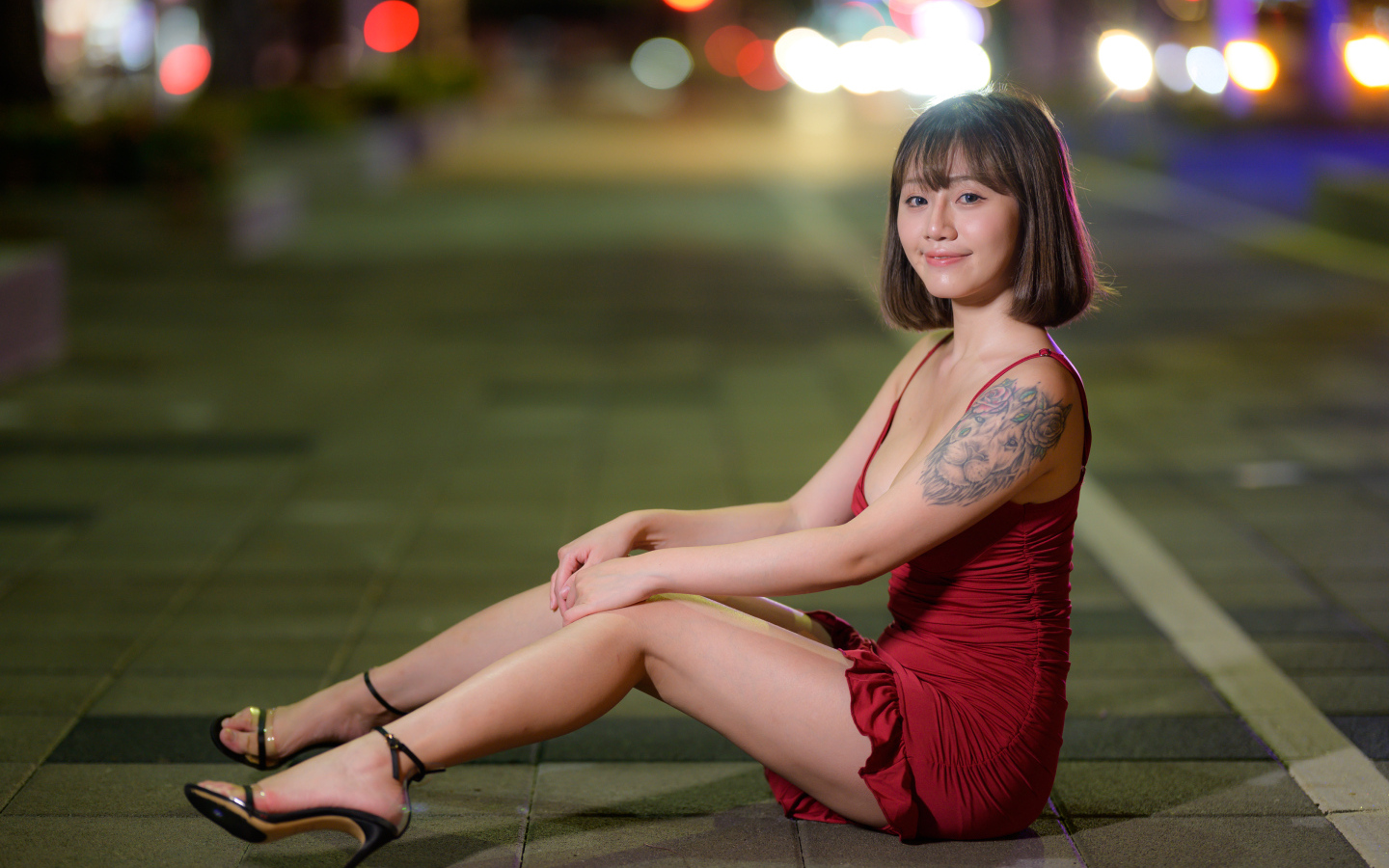 Азиатка с татуировкой на руке в красном платье