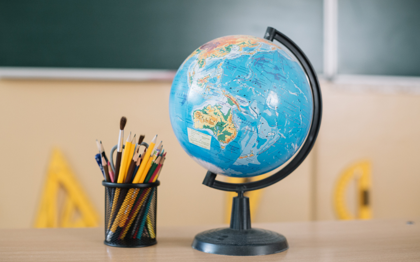 Глобус на столе с карандашами в школе