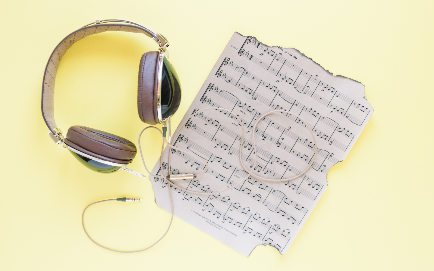 Старые ноты и наушники на желтом фоне
