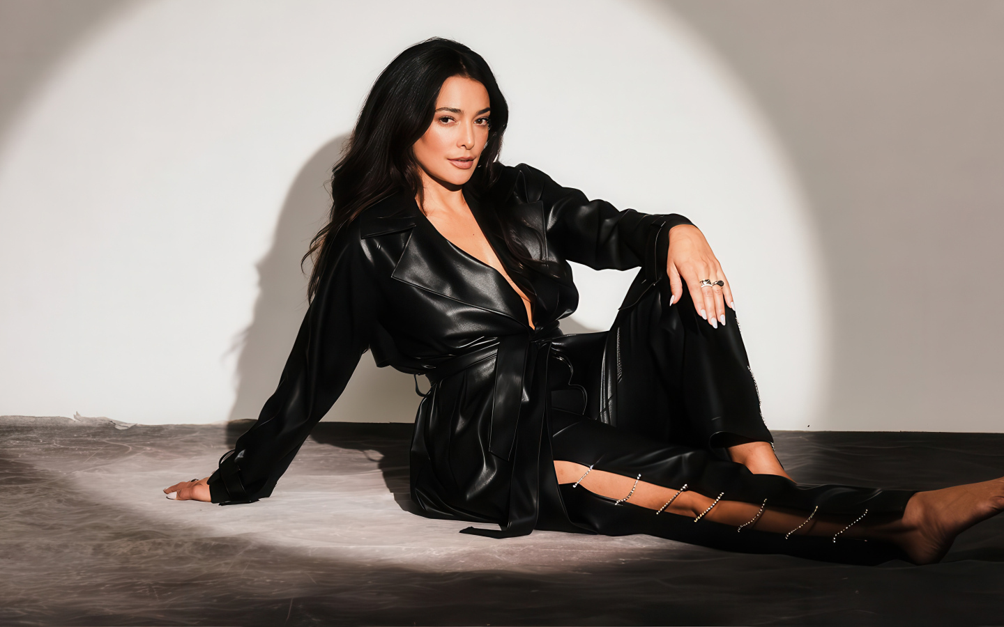 Актриса Натали Мартинес в черном кожаном костюме на фоне серой стены