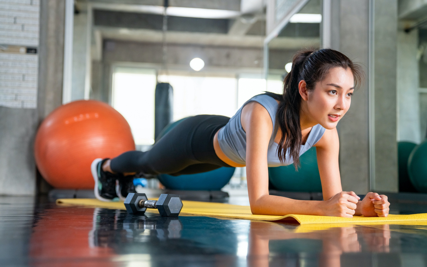 Спортивная девушка делает планку в спортзале