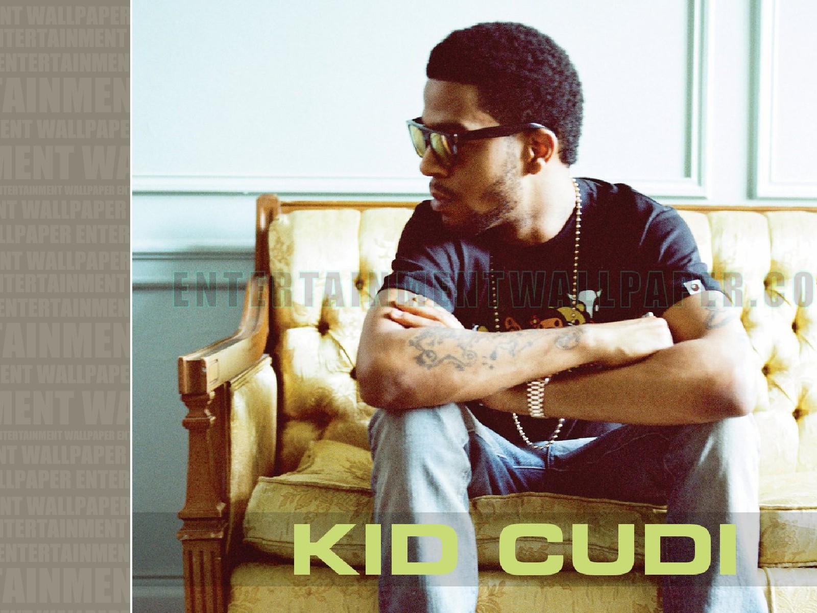 Kid Cudi сидит на желтом диване