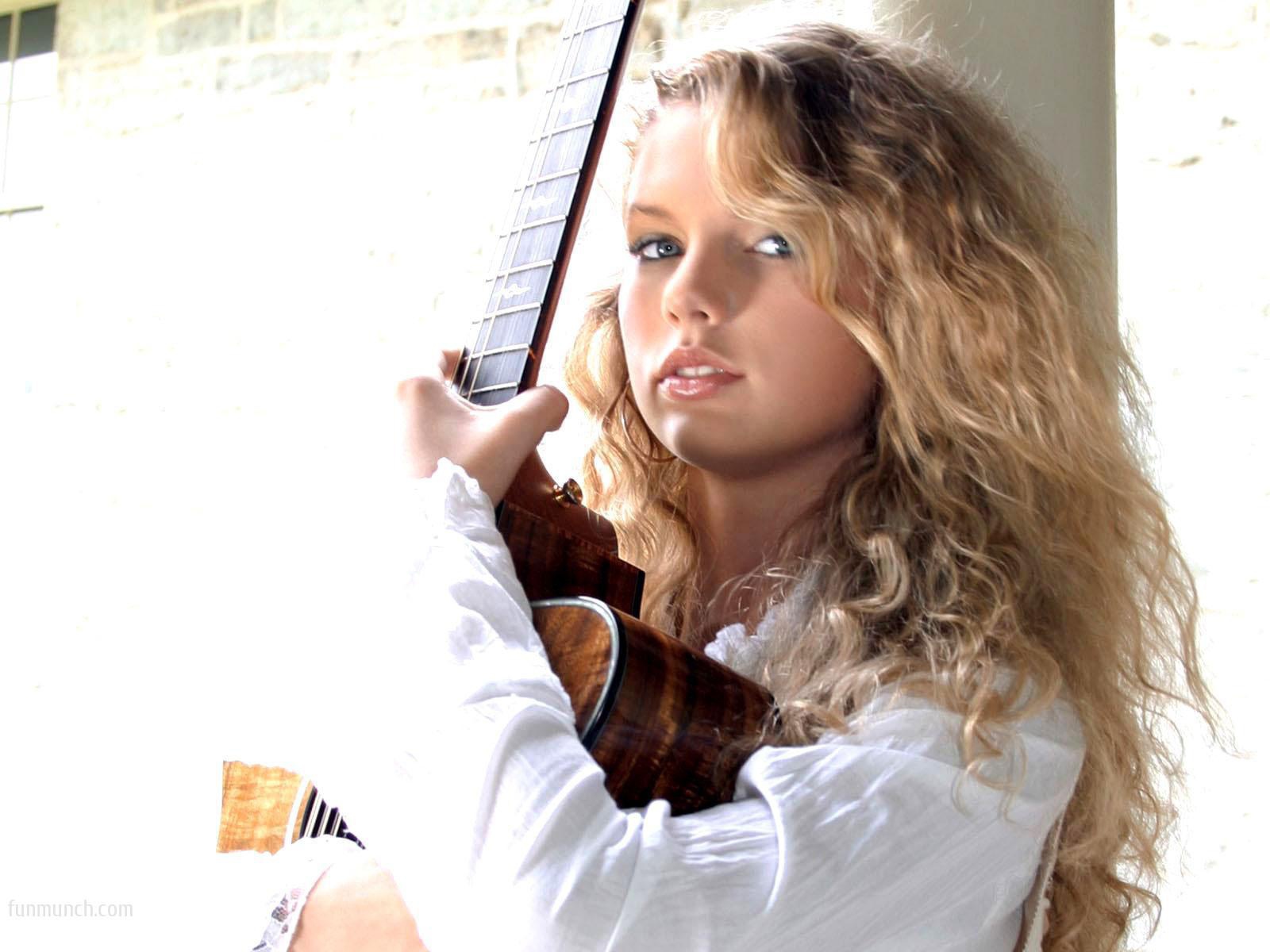 Taylor Swift обнимает свою гитару