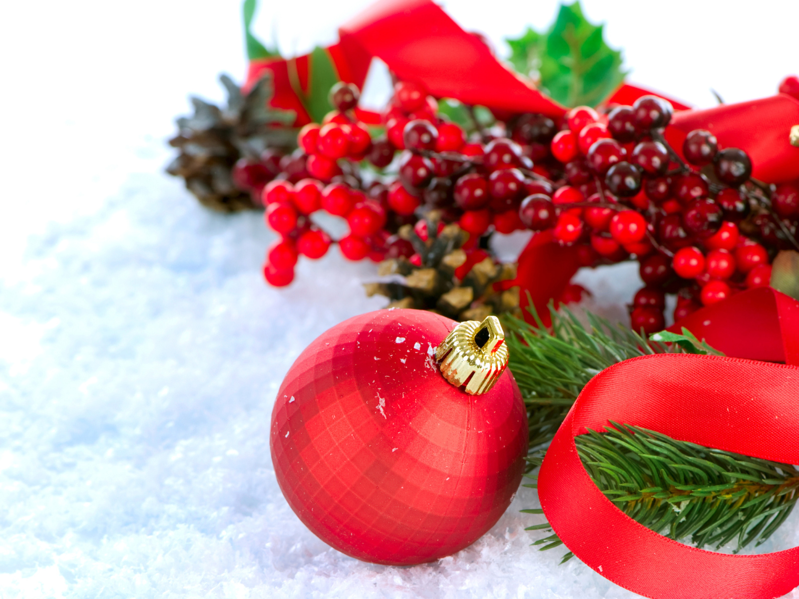 Красные ёлочные украшения на снегу