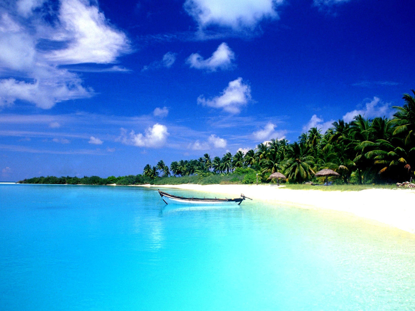 Белая лодка на лазурной воде в Гоа