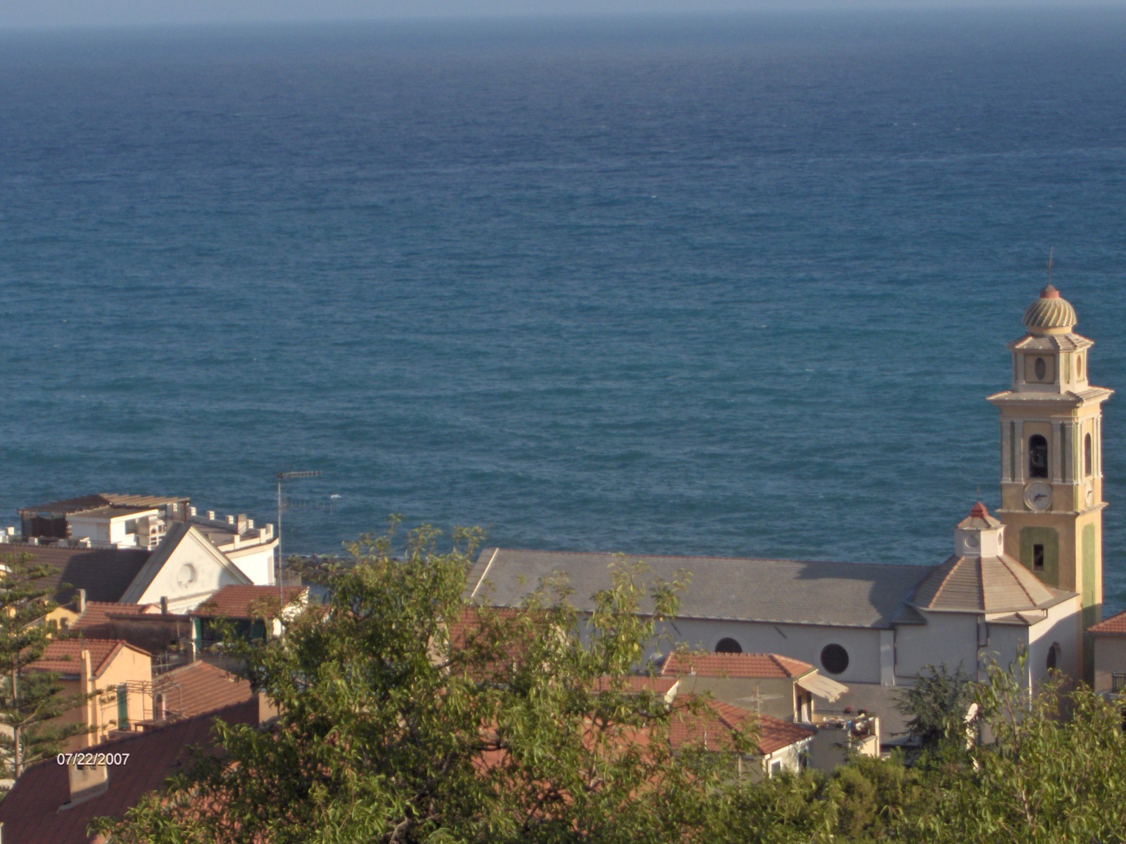 Башня с часами на фоне моря в Санто Стефано аль Маре, Италия