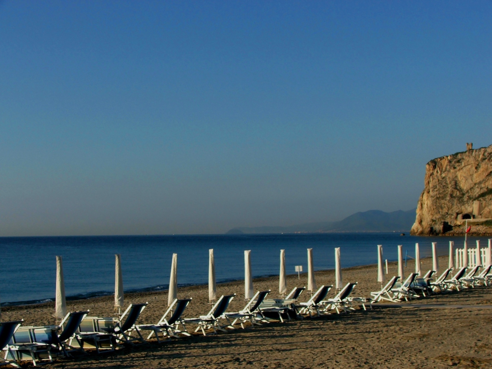 Лежаки на пляже на курорте Финале Лигуре, Италия