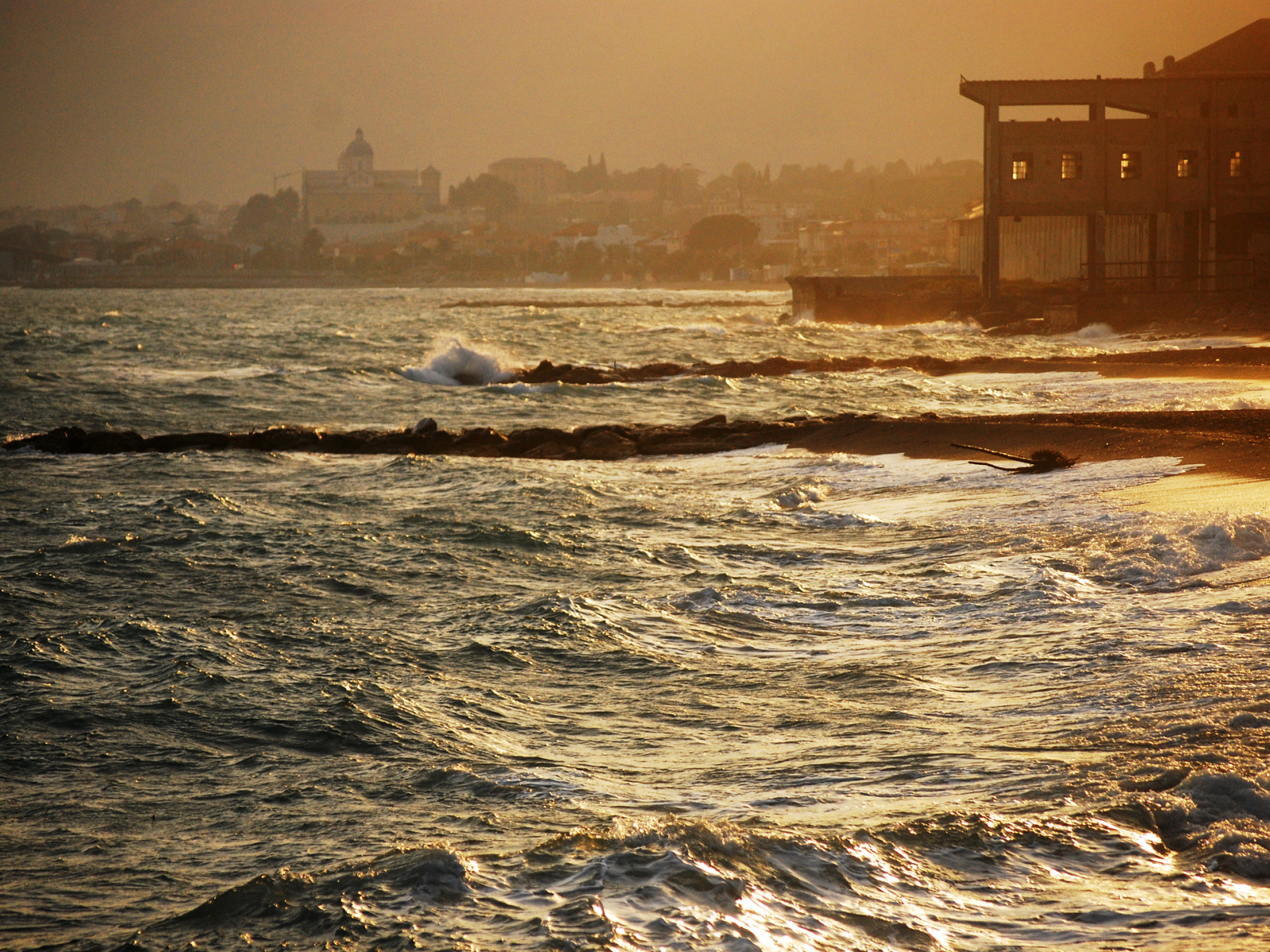 Закат на пляже на курорте в Пьетра Лигуре, Италия
