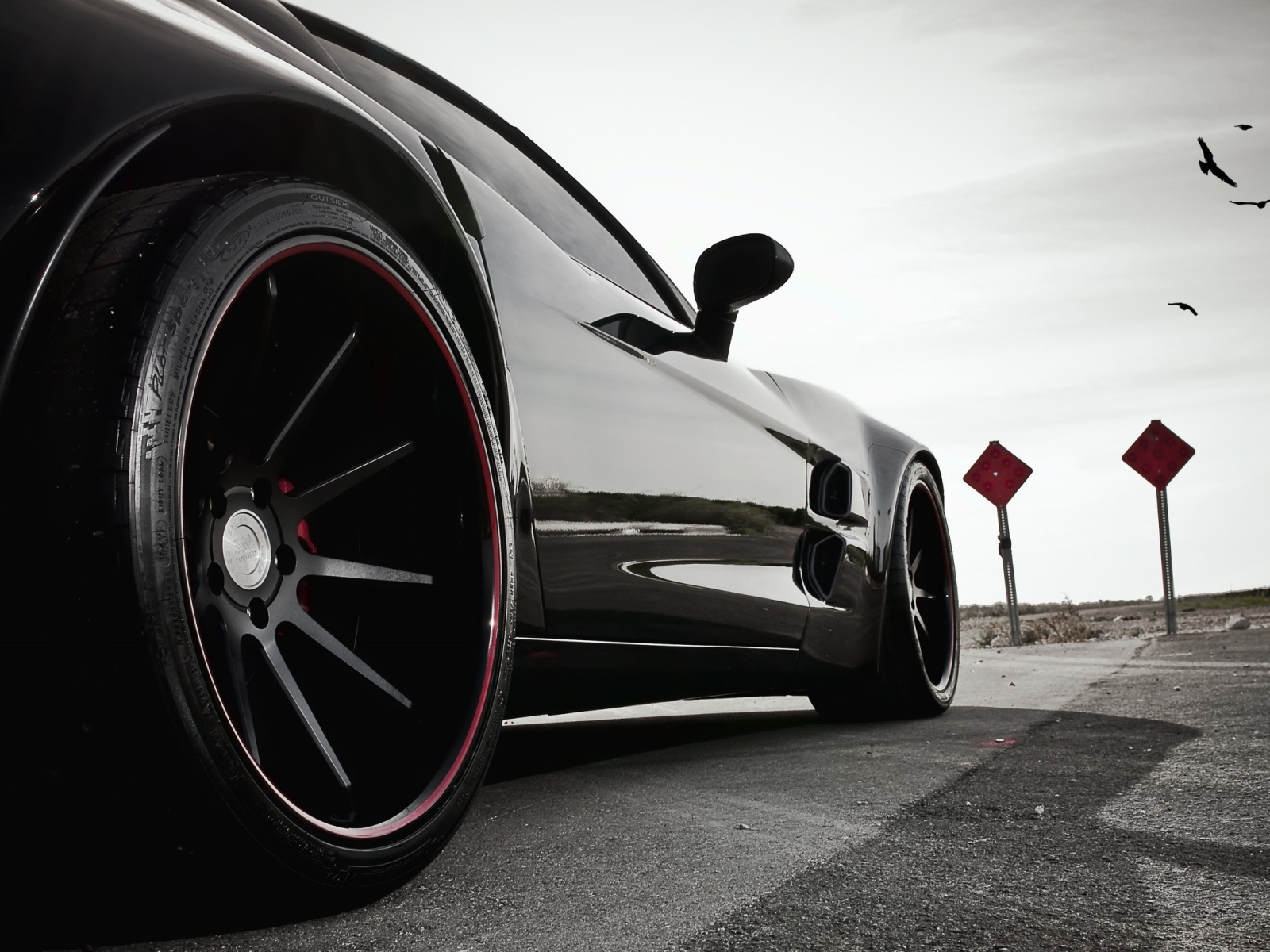 Черный автомобиль перед дорожными знаками