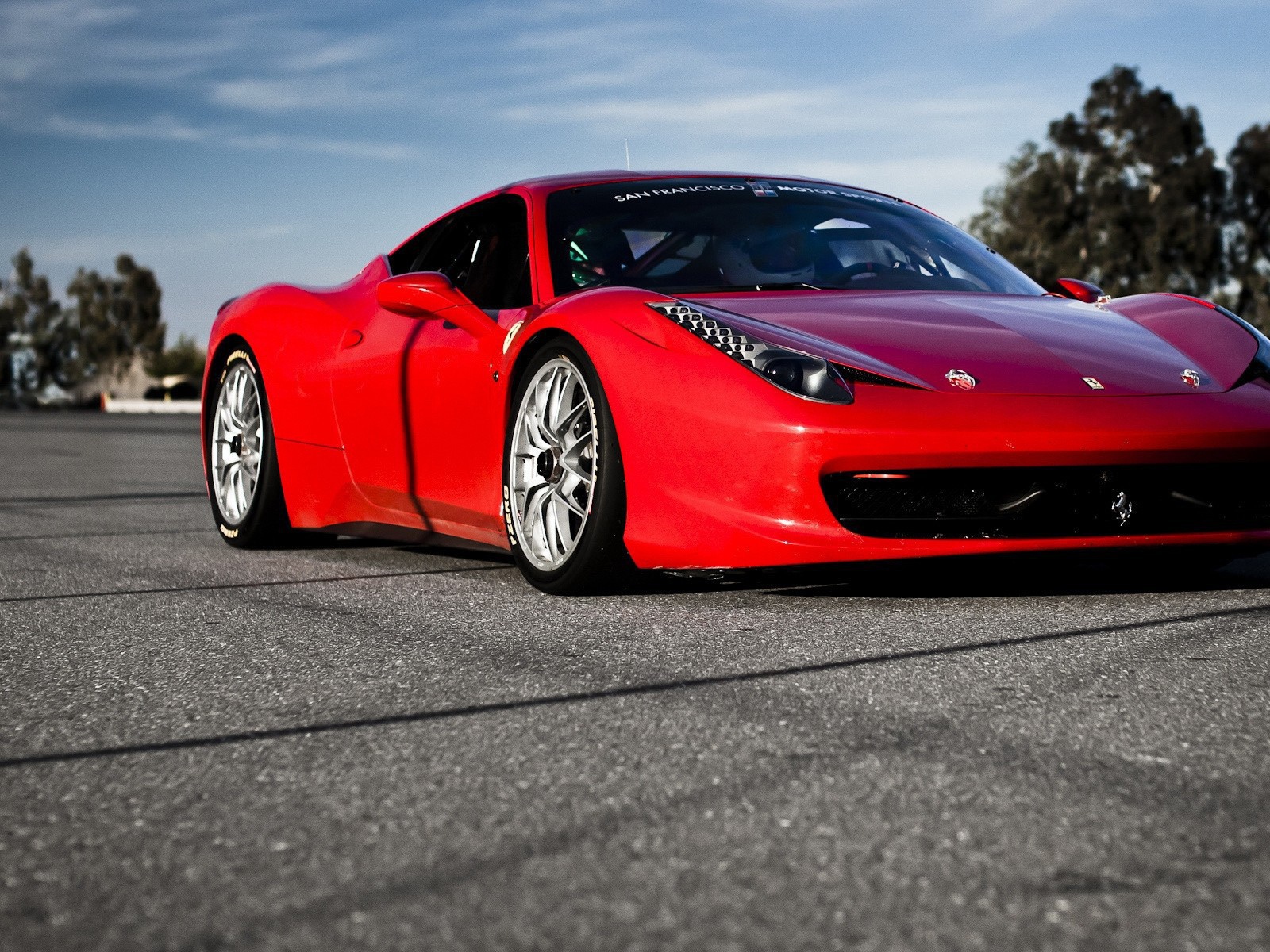 Красный спортивный автомобиль на гладком сером асфальте