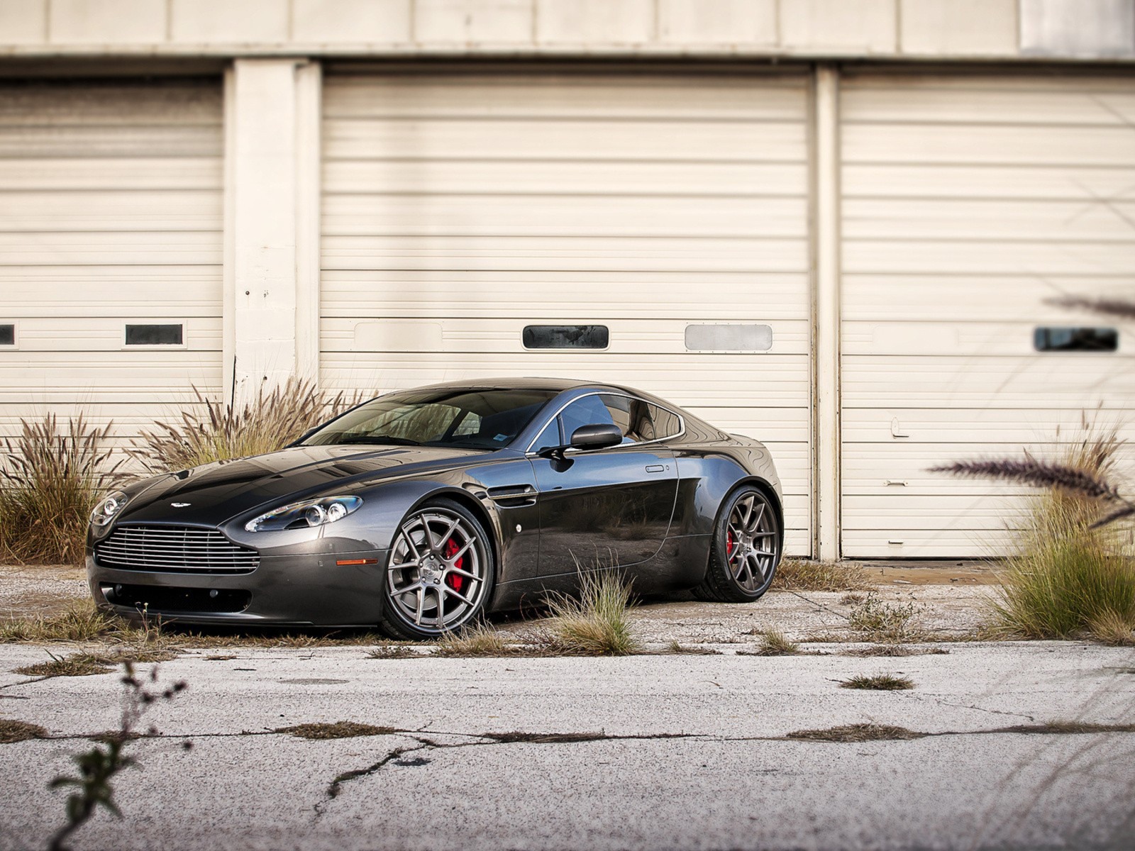 Черный Aston Martin в ворот белого ангара