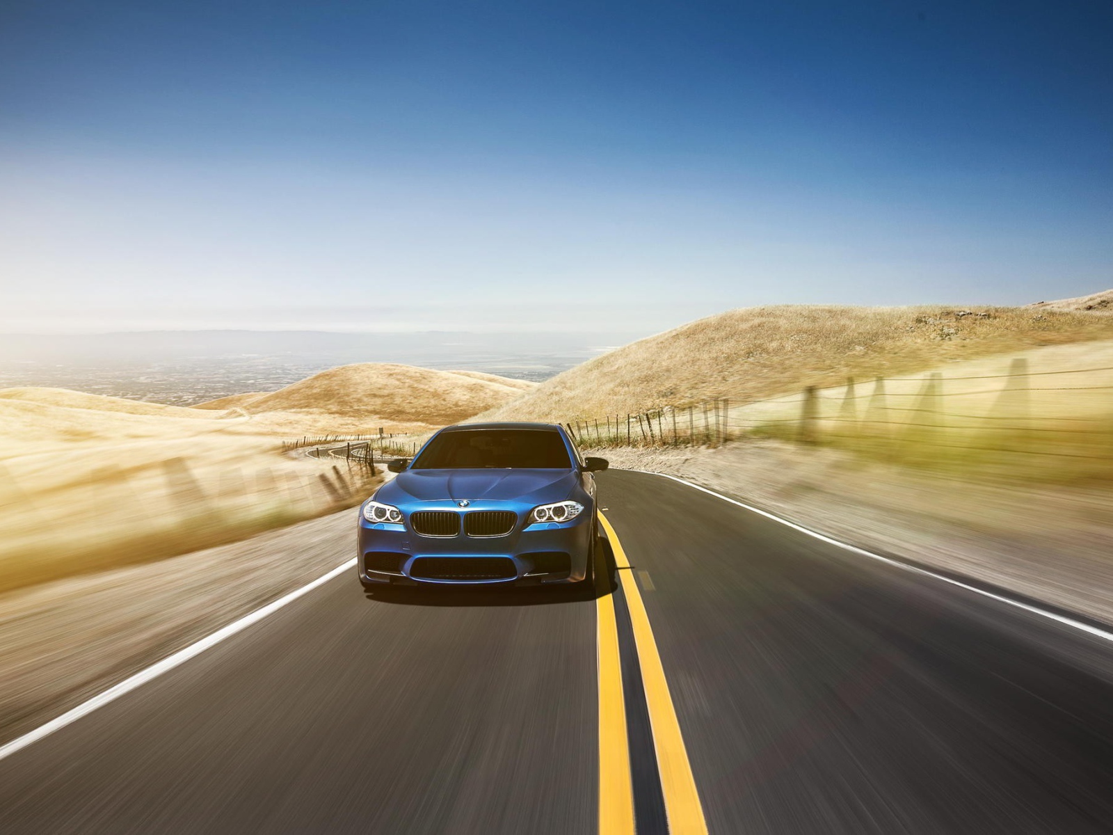 Голубой BMW мчится по шоссе в пустыне
