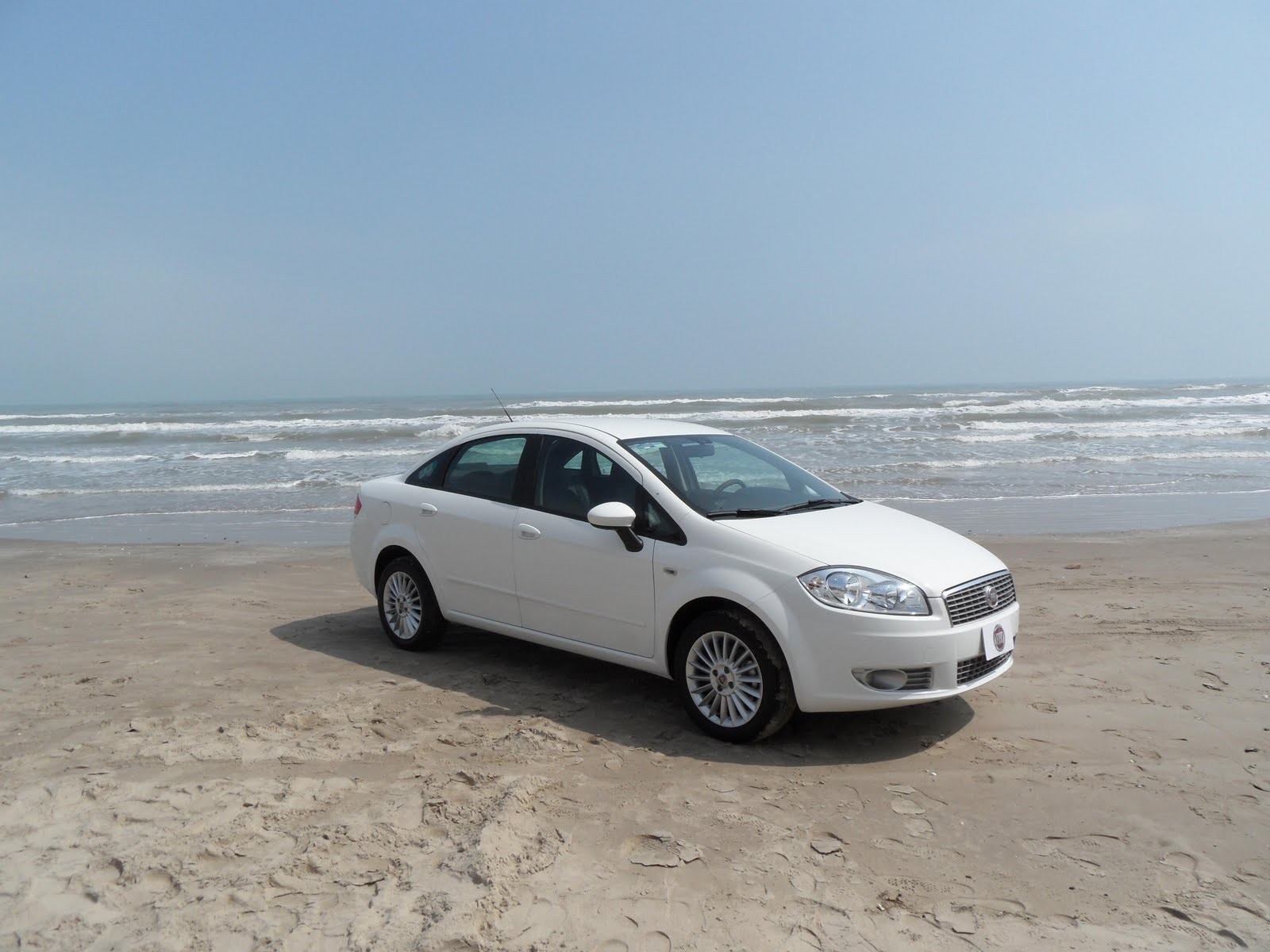 Белый Фиат на песке пляжа