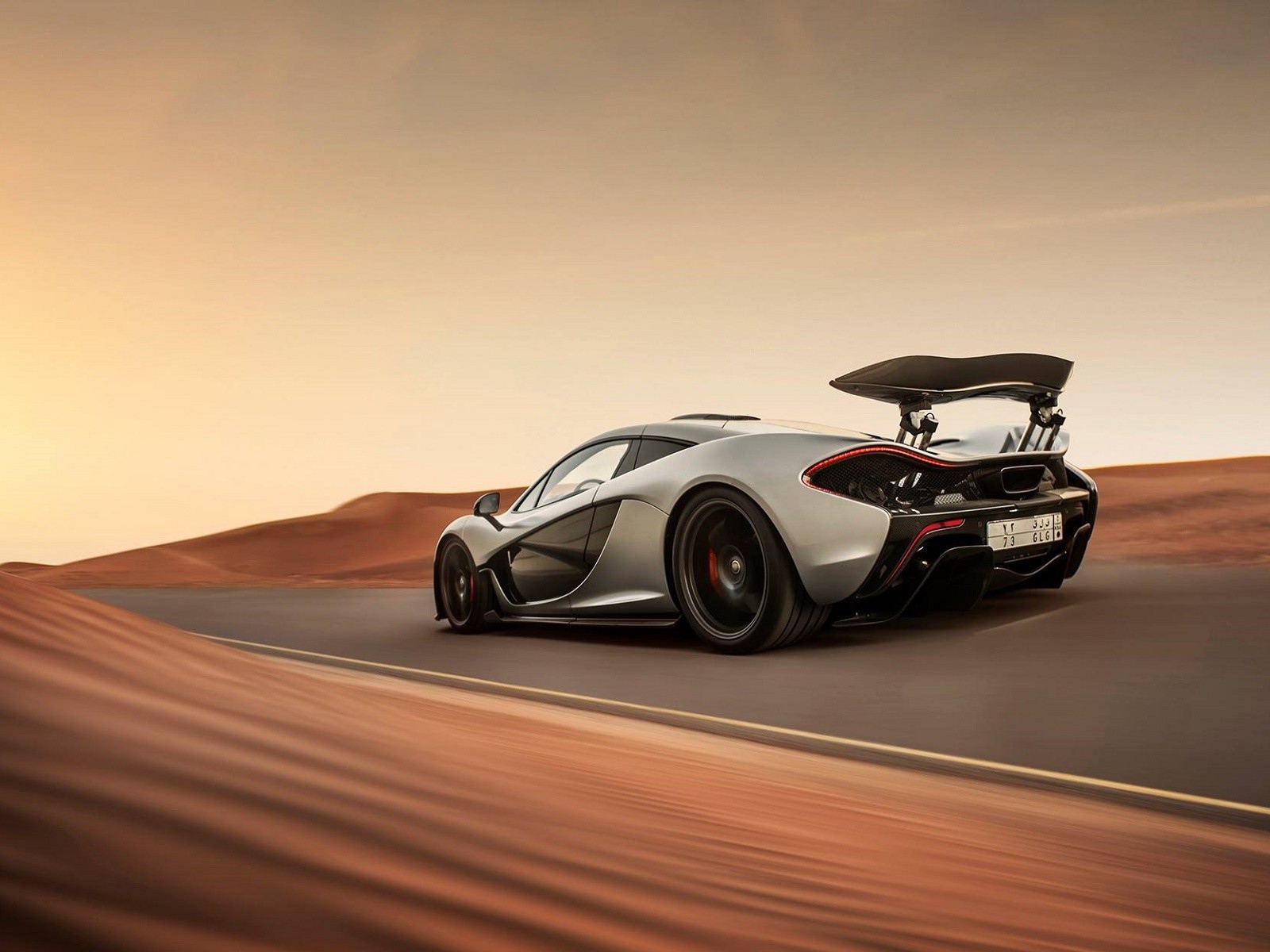 Серый McLaren P1 на шоссе в пустыне