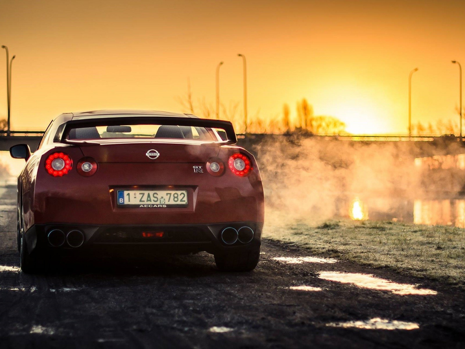 Красный Nissan у реки на рассвете