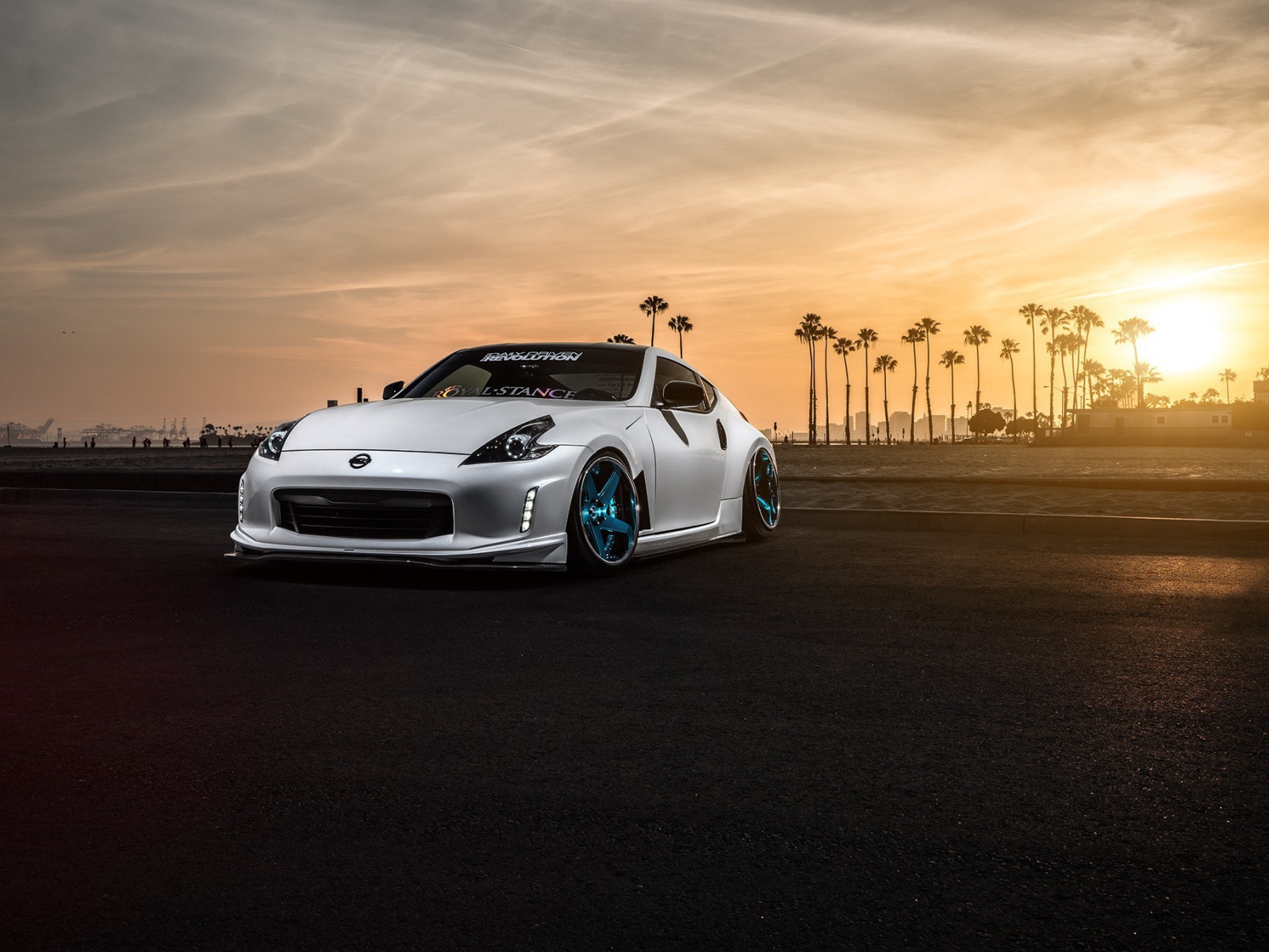 Белый Nissan 370Z на фоне пальм и заката