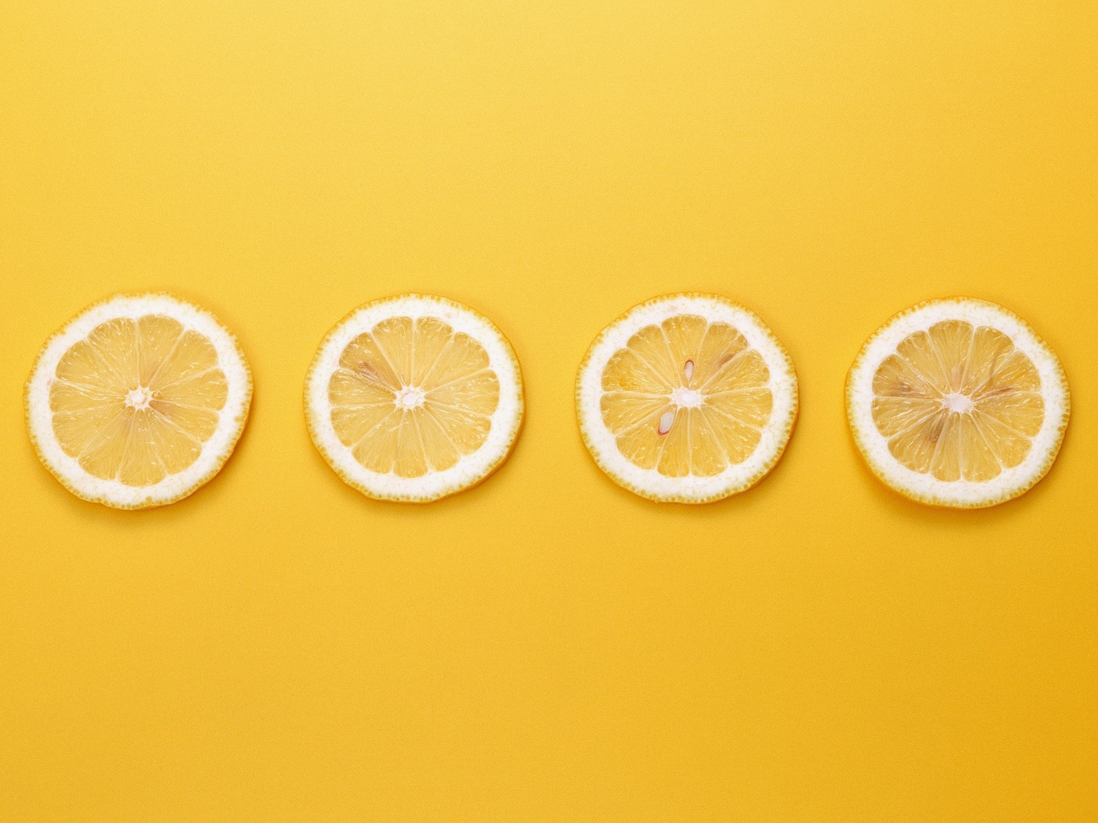 Кружки лимона, желтый фон