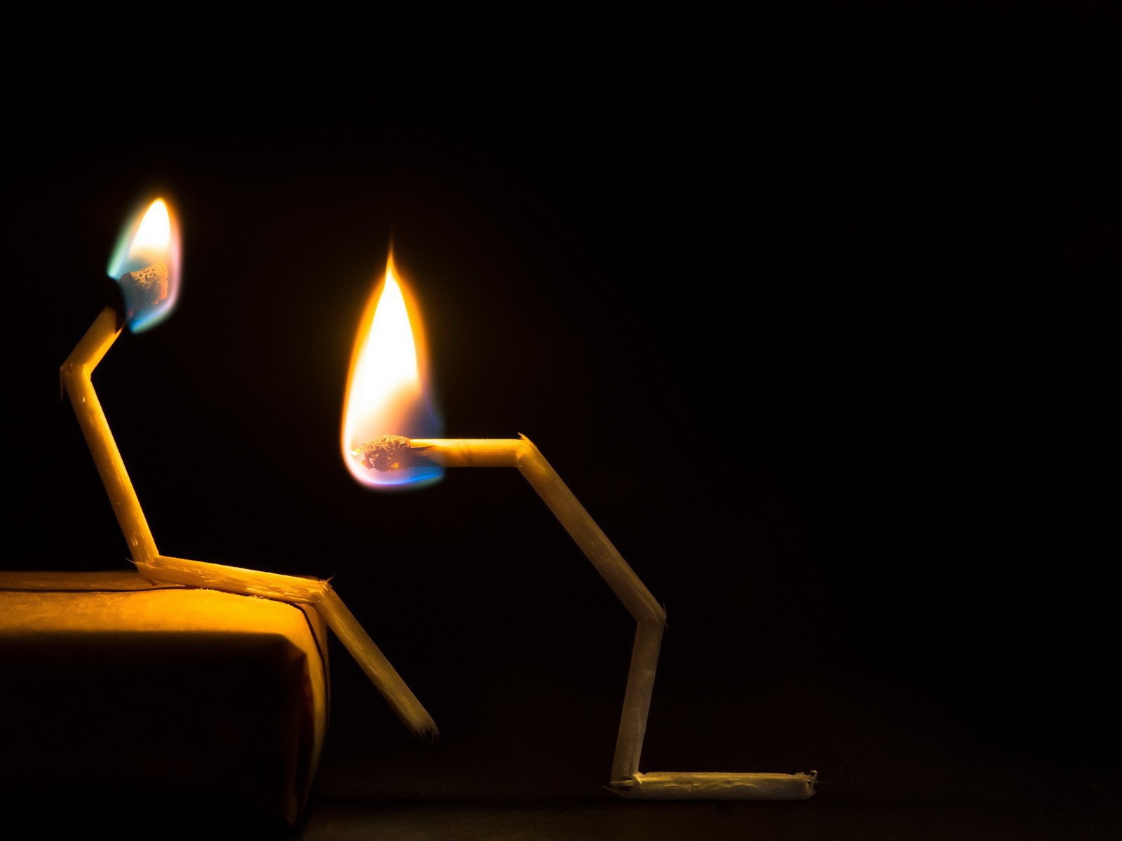 Пара горящих сломанных спичек