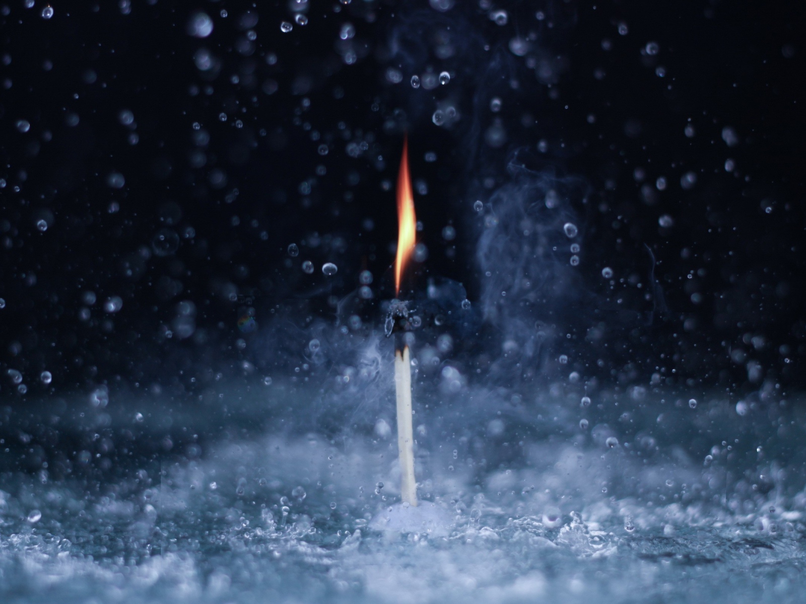 Пламя спички среди капель воды