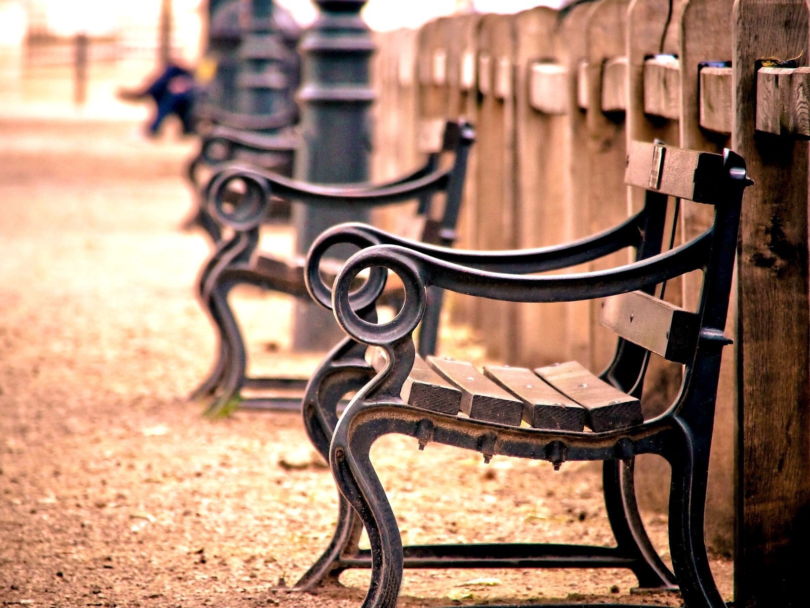Кованые скамьи у деревянного забора