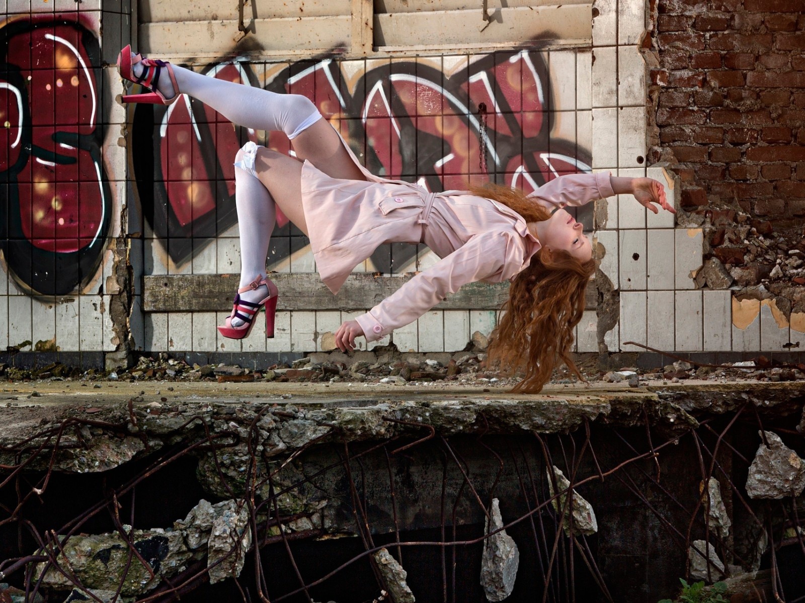 Девушка выполняет трюк на фоне граффити