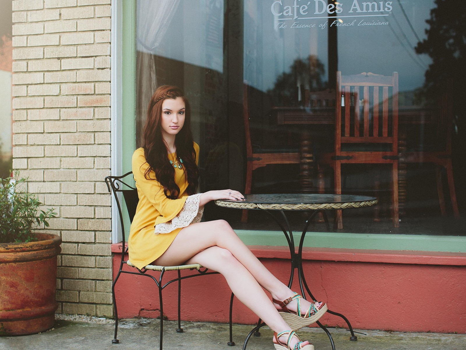 Девушка сидит за столиком уличного кафе