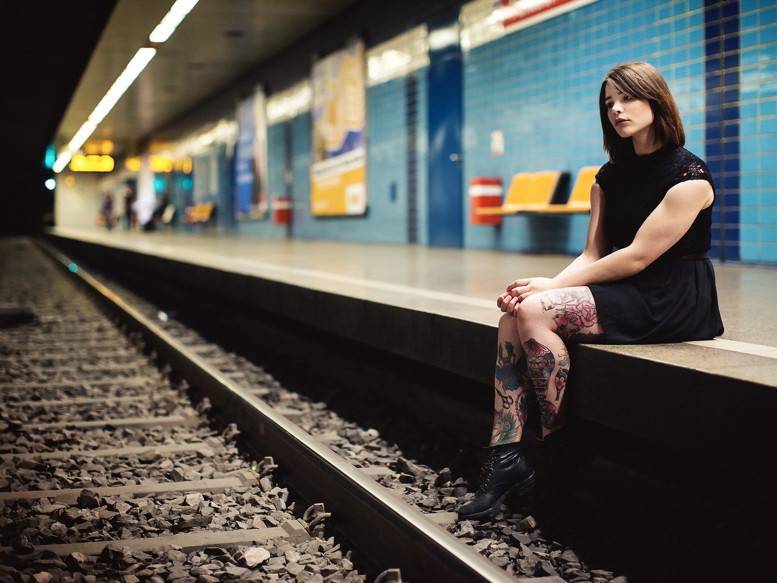 Девушка ждет поезд на станции метро
