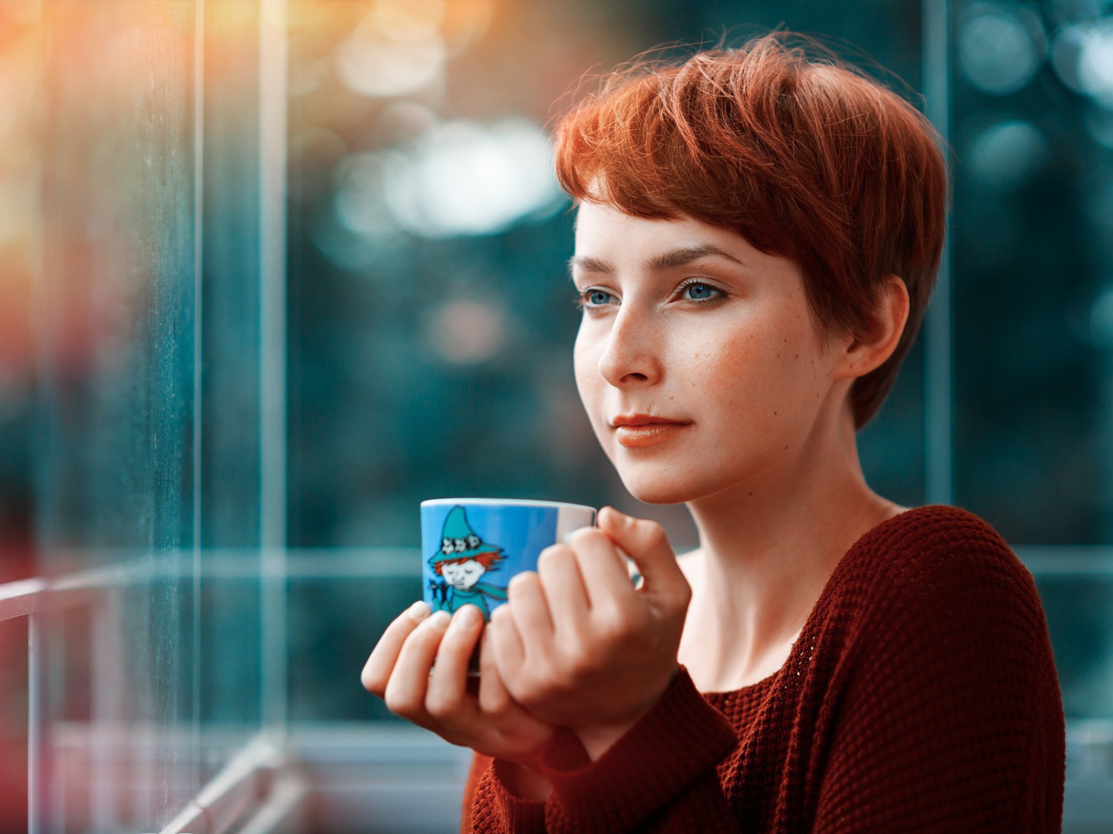 Девушка с короткими волосами пьет кофе