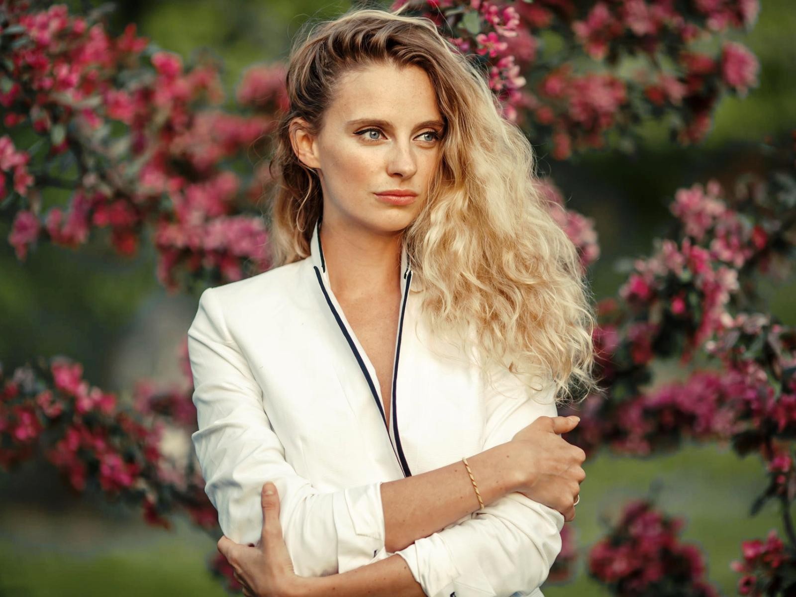 Голубоглазая блондинка на фоне цветущих деревьев