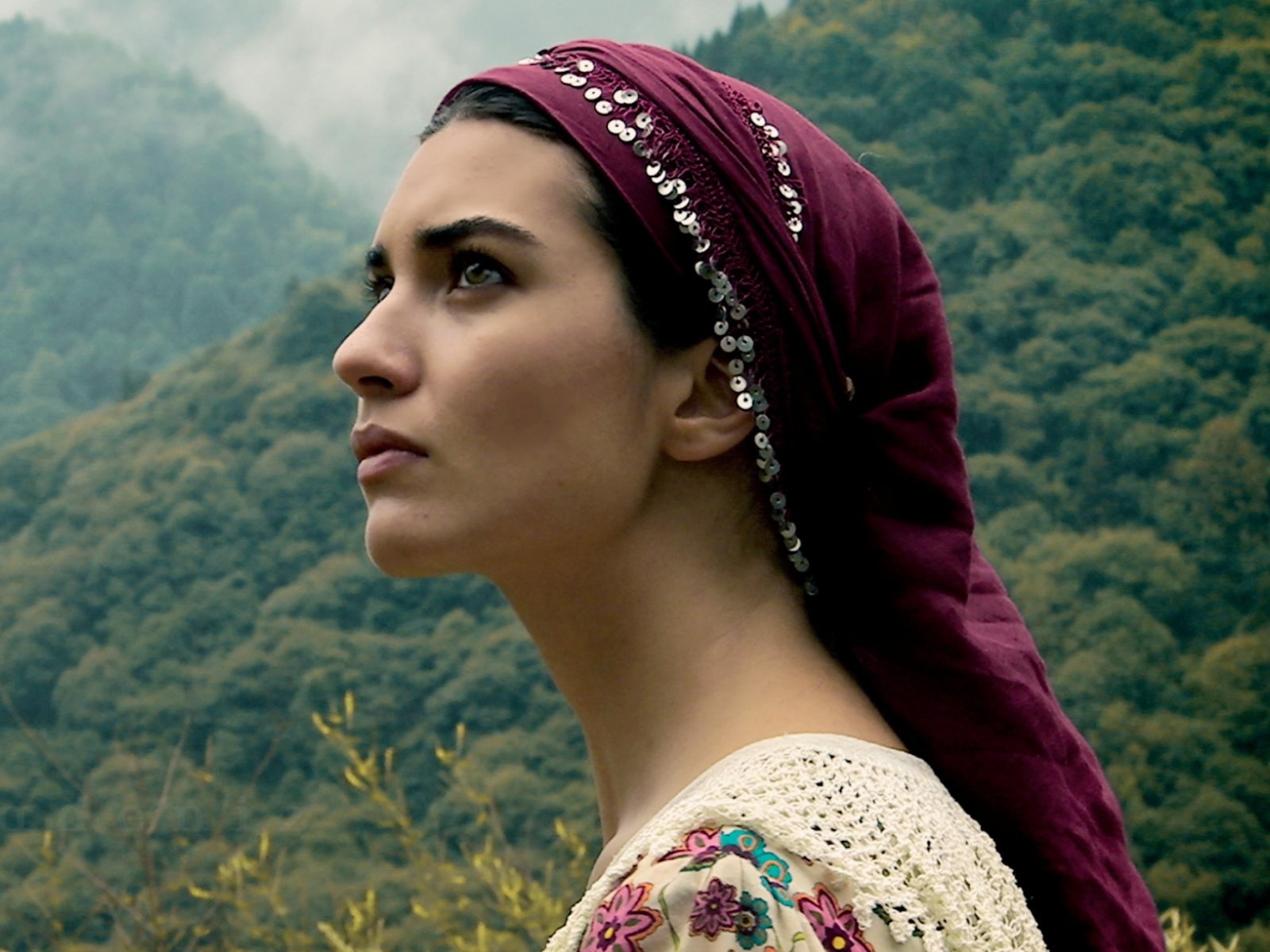 Девушка в красной косынке на фоне горного леса