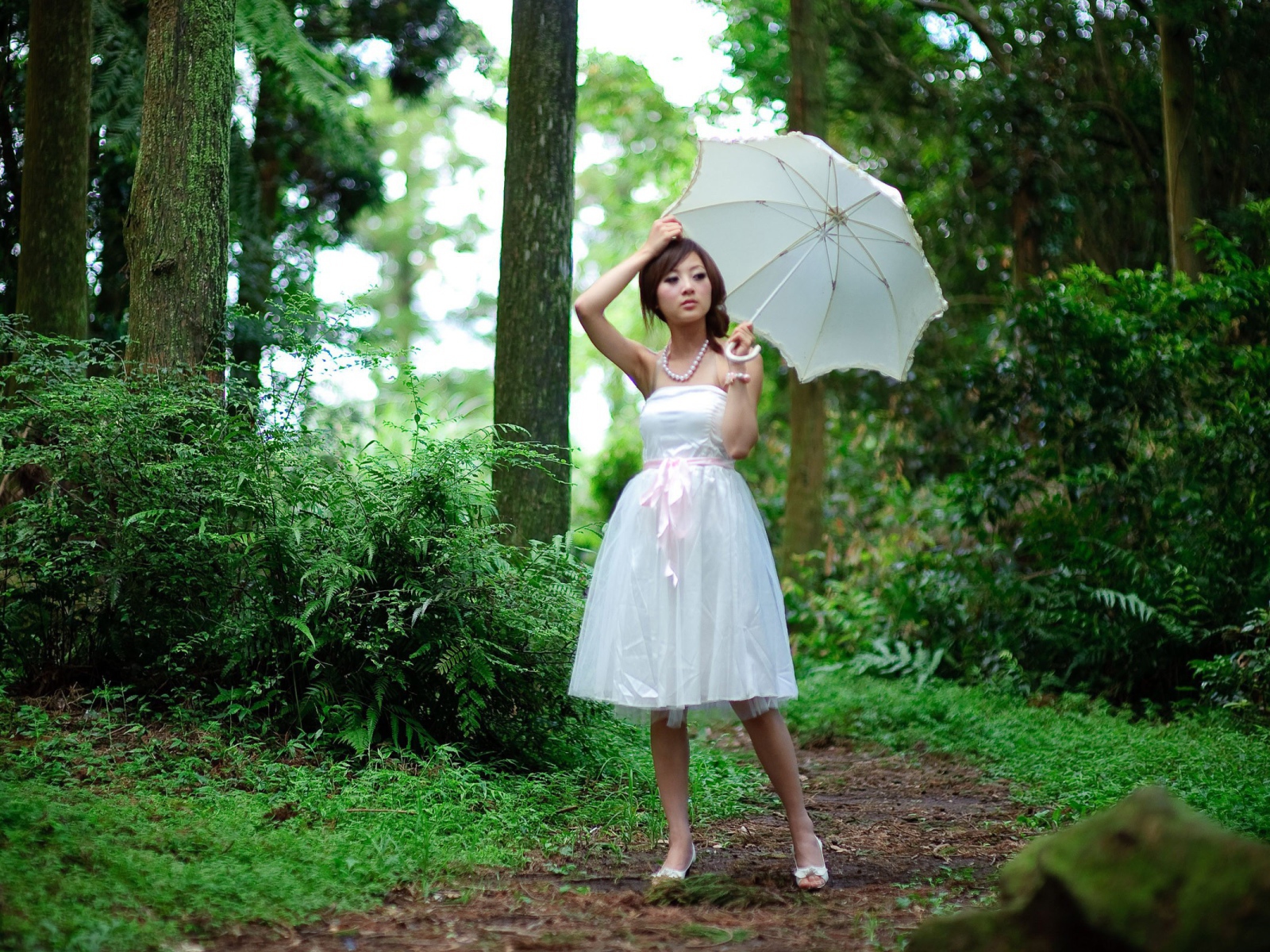 Девушка в белым зонтом в лесу