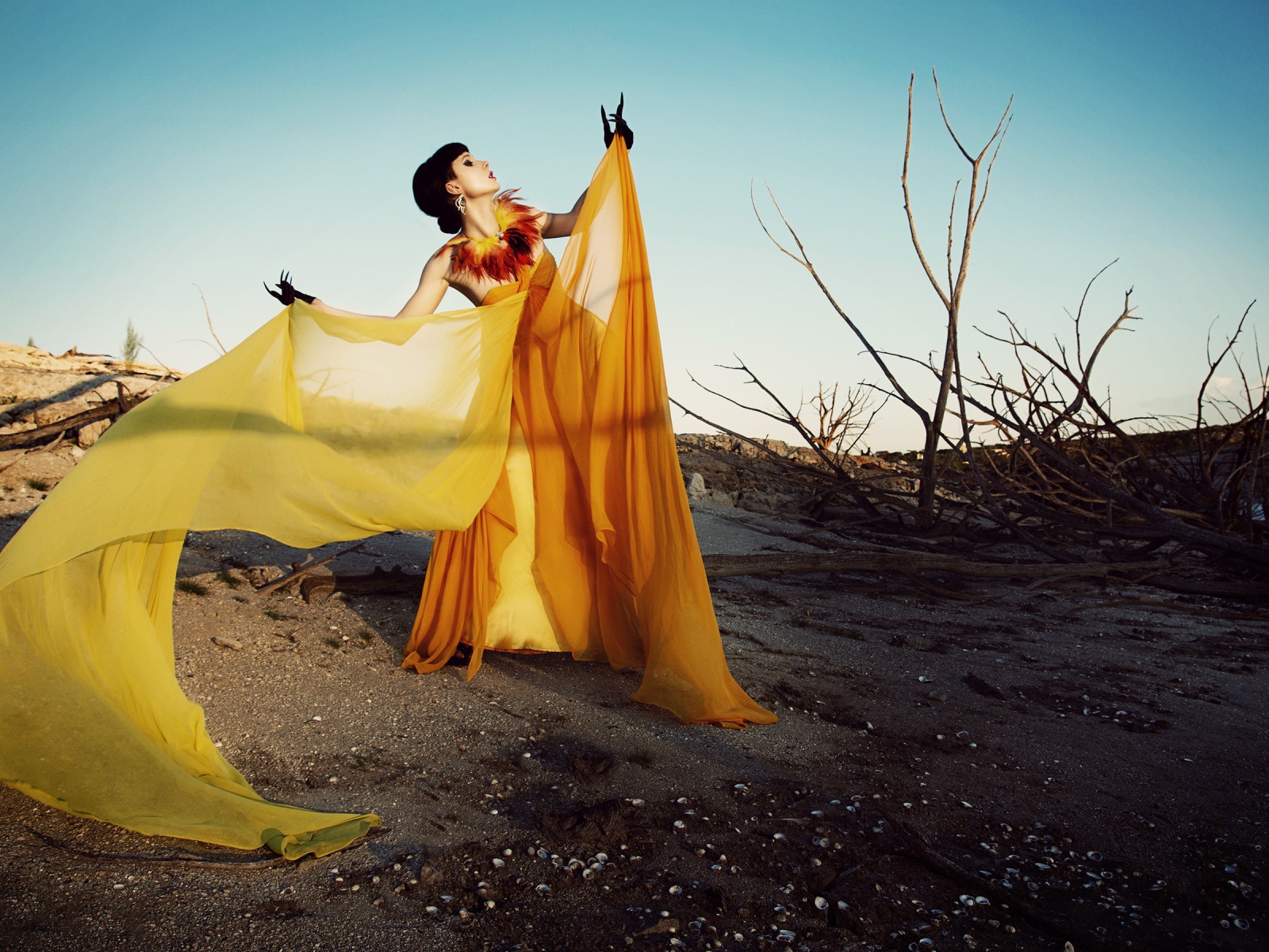 Девушка в оранжевом позирует в пустыне