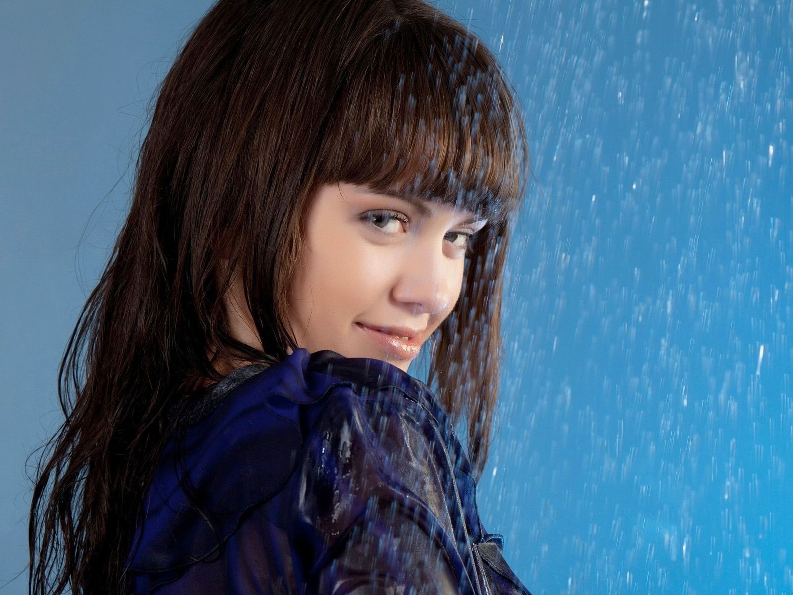 Девушка стоит под струей воды