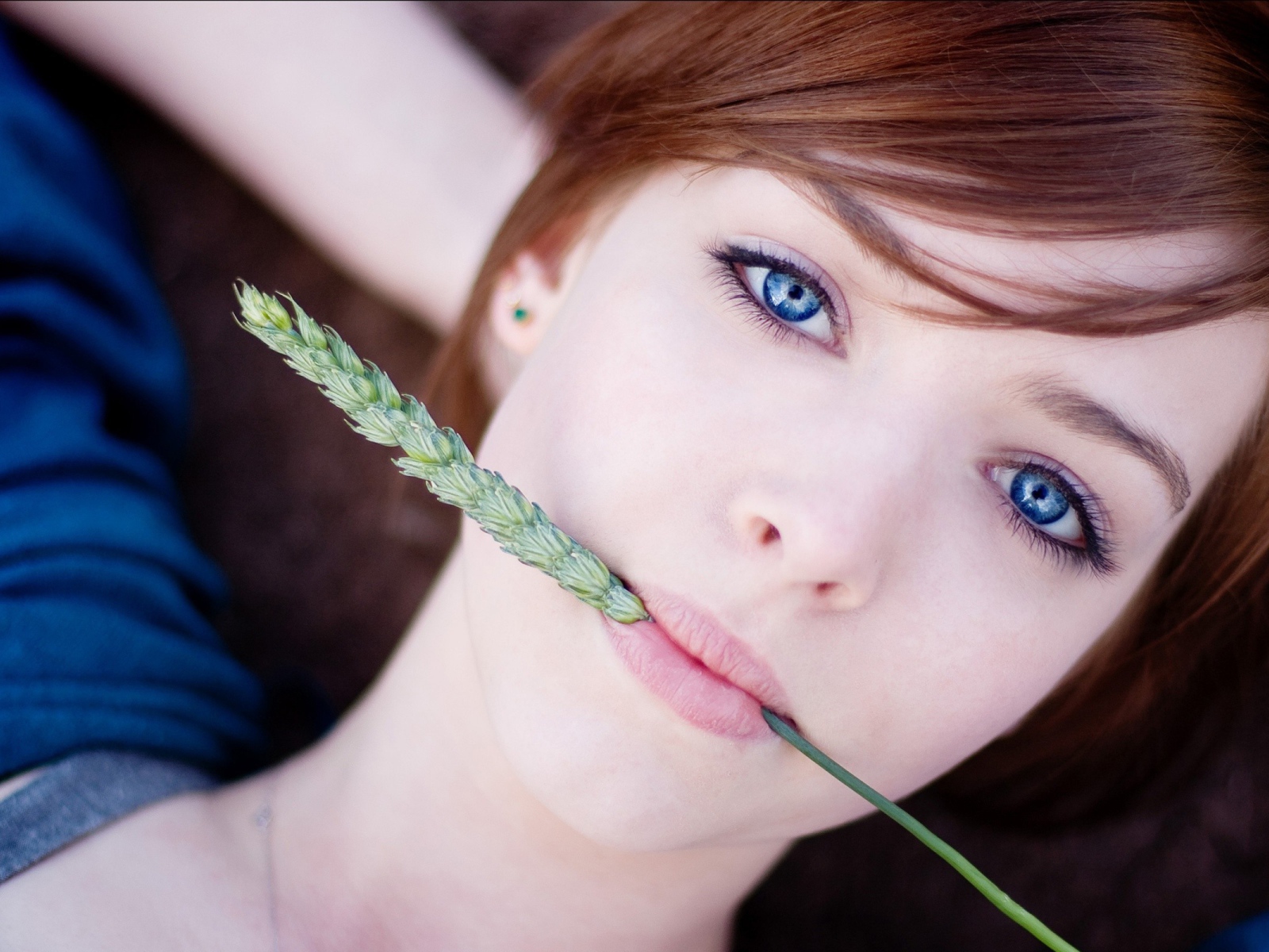 Зеленый колосок во рту у девушки