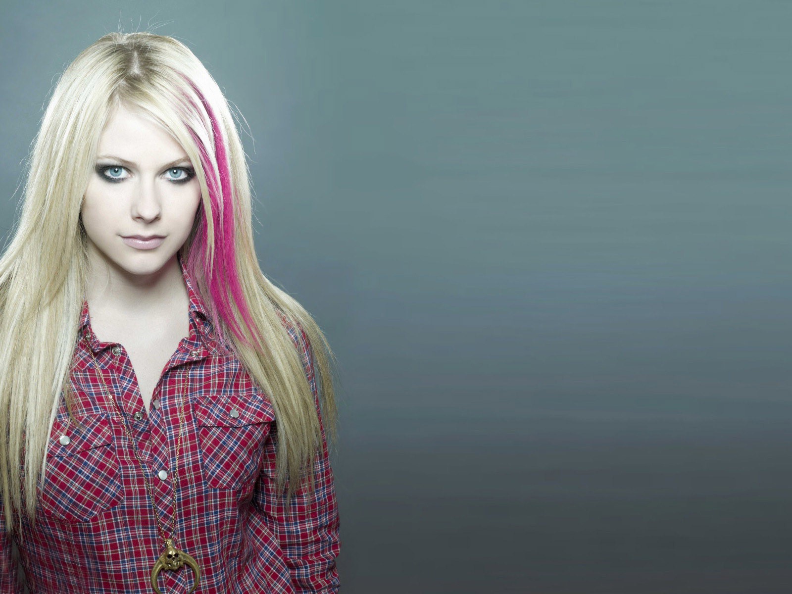 Розовая прядь волос у блондинки на сером фоне