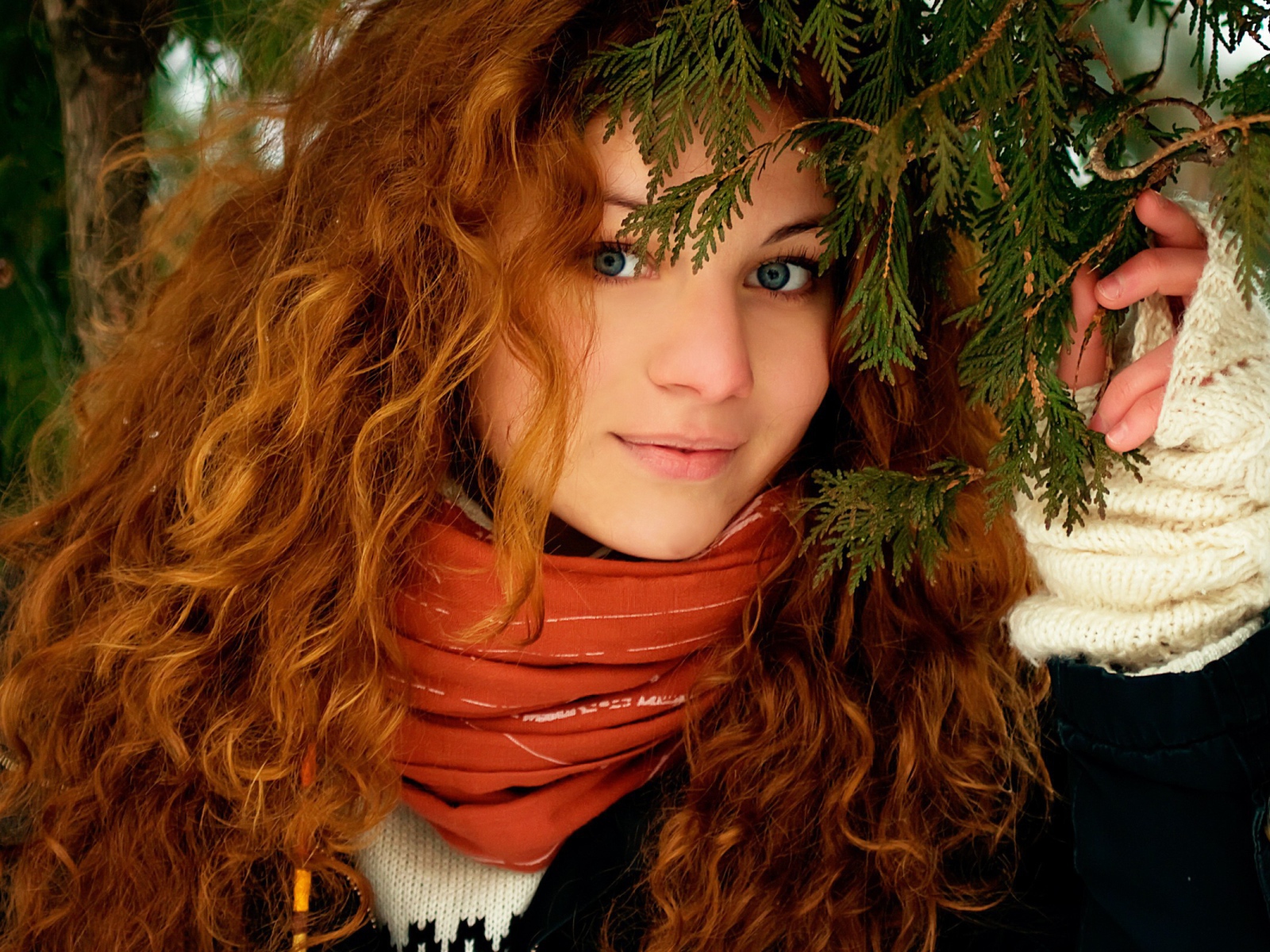 Рыжая девушка под ветками ели